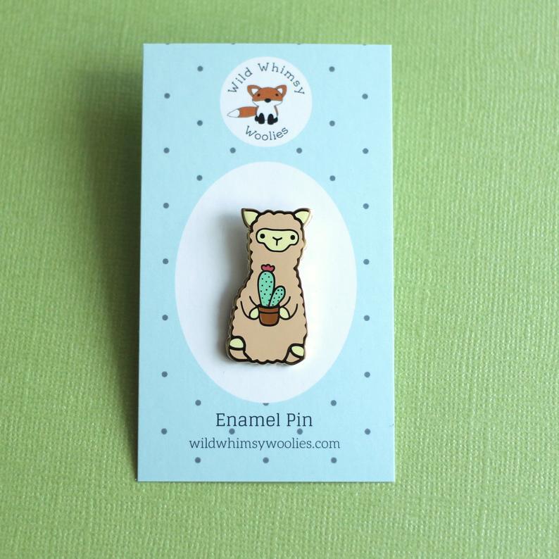 Wild Whimsy Alpaca Cactus Pin featuring a cute cactus design with a gold metal finish, perfect for accessories.