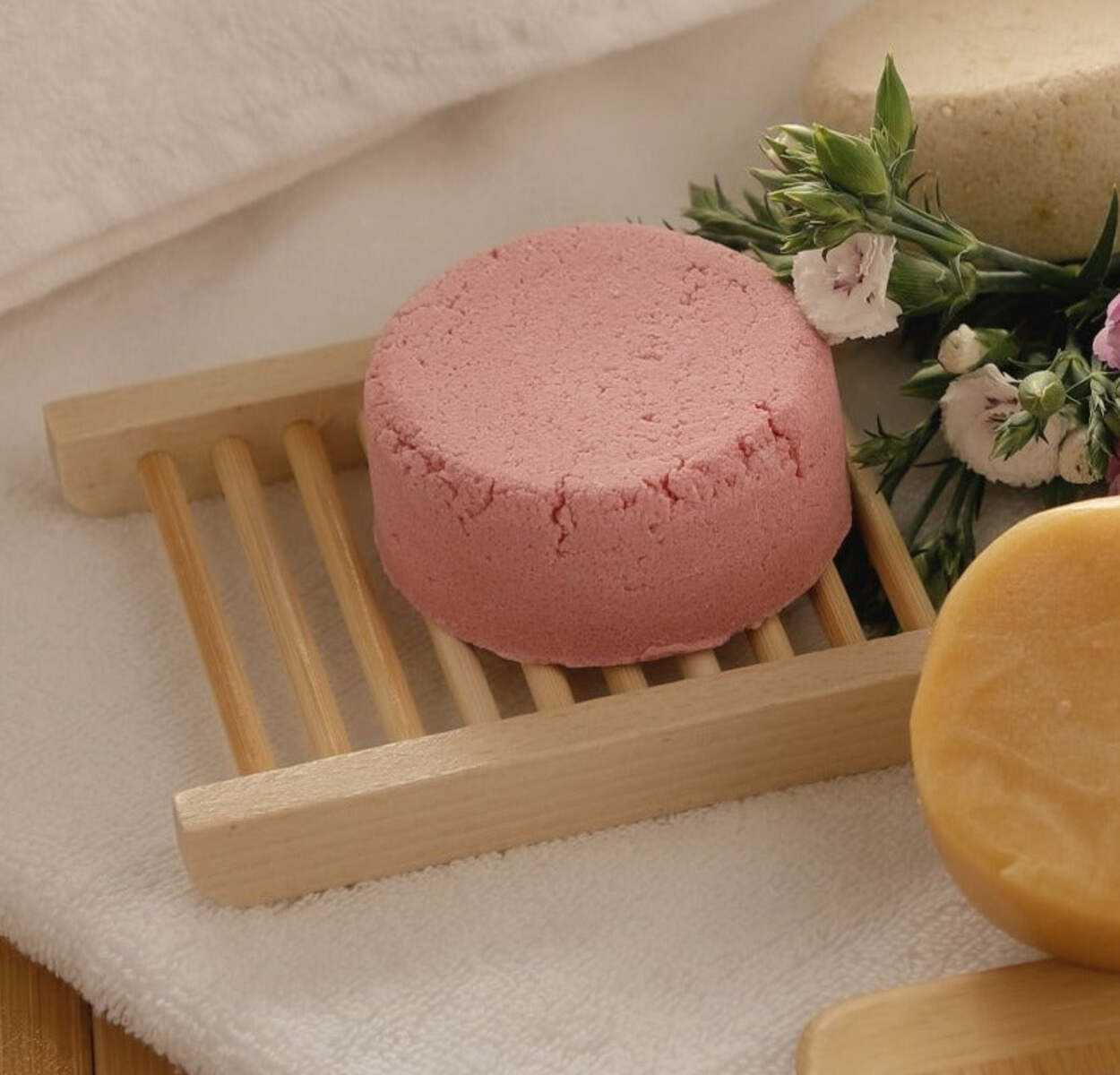 A collection of six eco-friendly bath accessories including a bamboo facial brush, massage brush, wooden detangling hairbrush, bamboo comb, scalp massager, and soap dish.