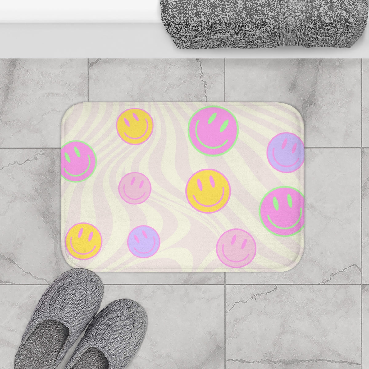 A colorful Smiley Faces Bath Mat featuring a playful design with smiley faces, made of soft microfiber with anti-slip backing.