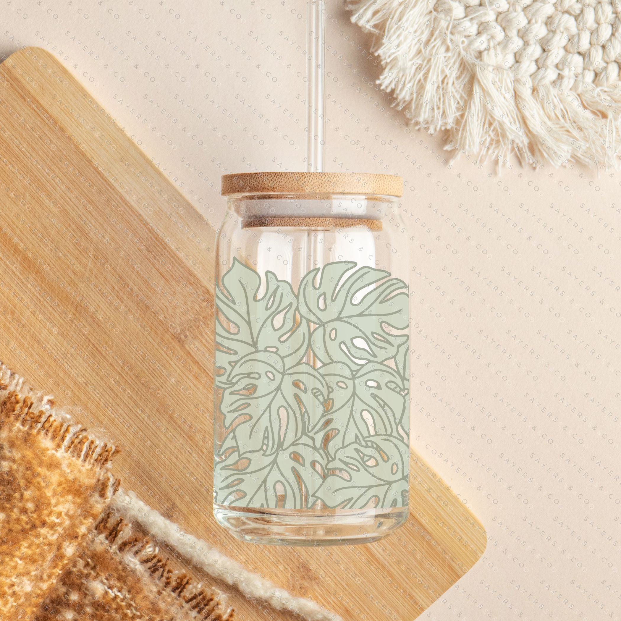 16oz Monstera Jungle Glass Cup with bamboo lid and straw, featuring a vibrant tropical design.