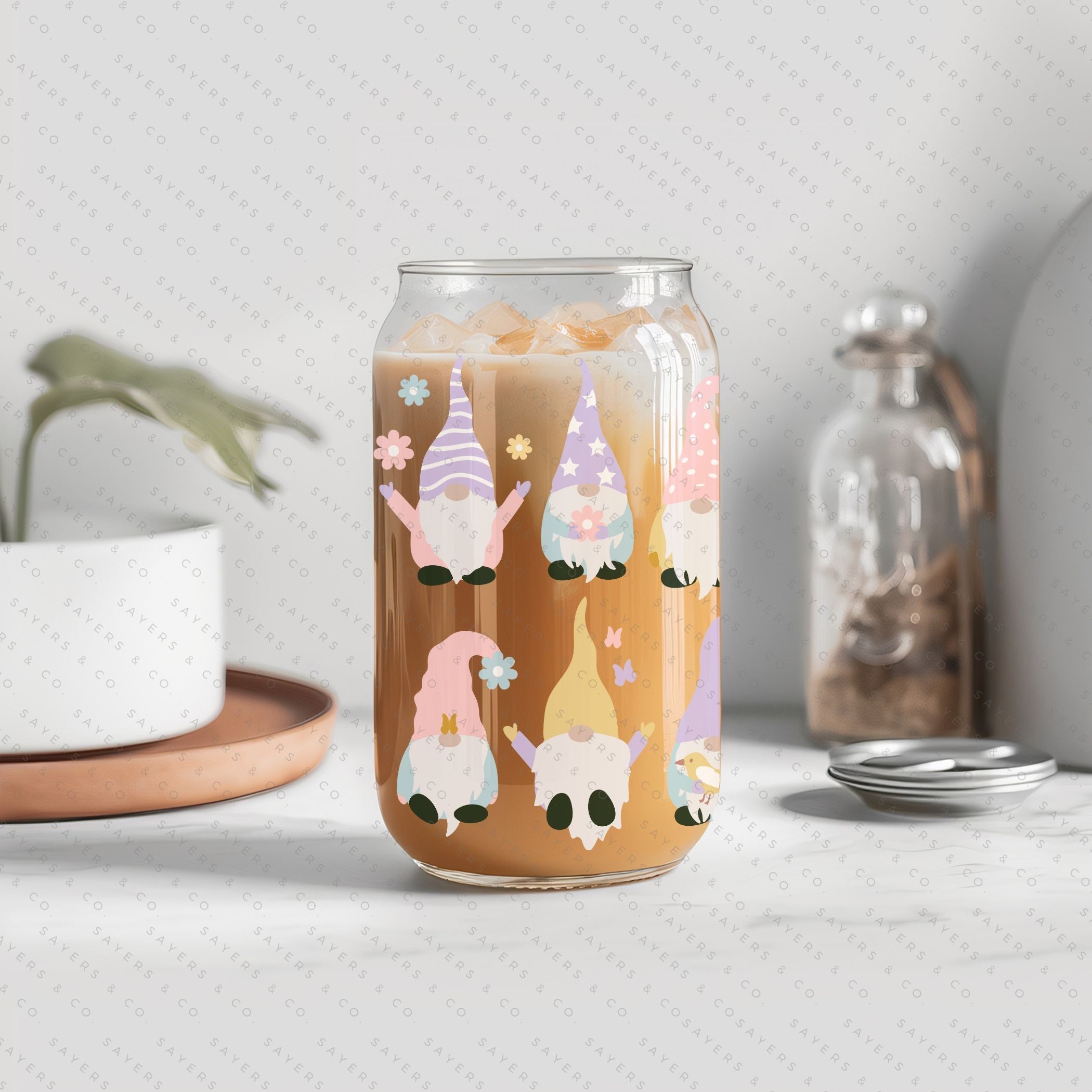 A 16oz clear glass cup featuring a whimsical spring gnome design, complete with a bamboo lid and a clear plastic straw, perfect for various beverages.