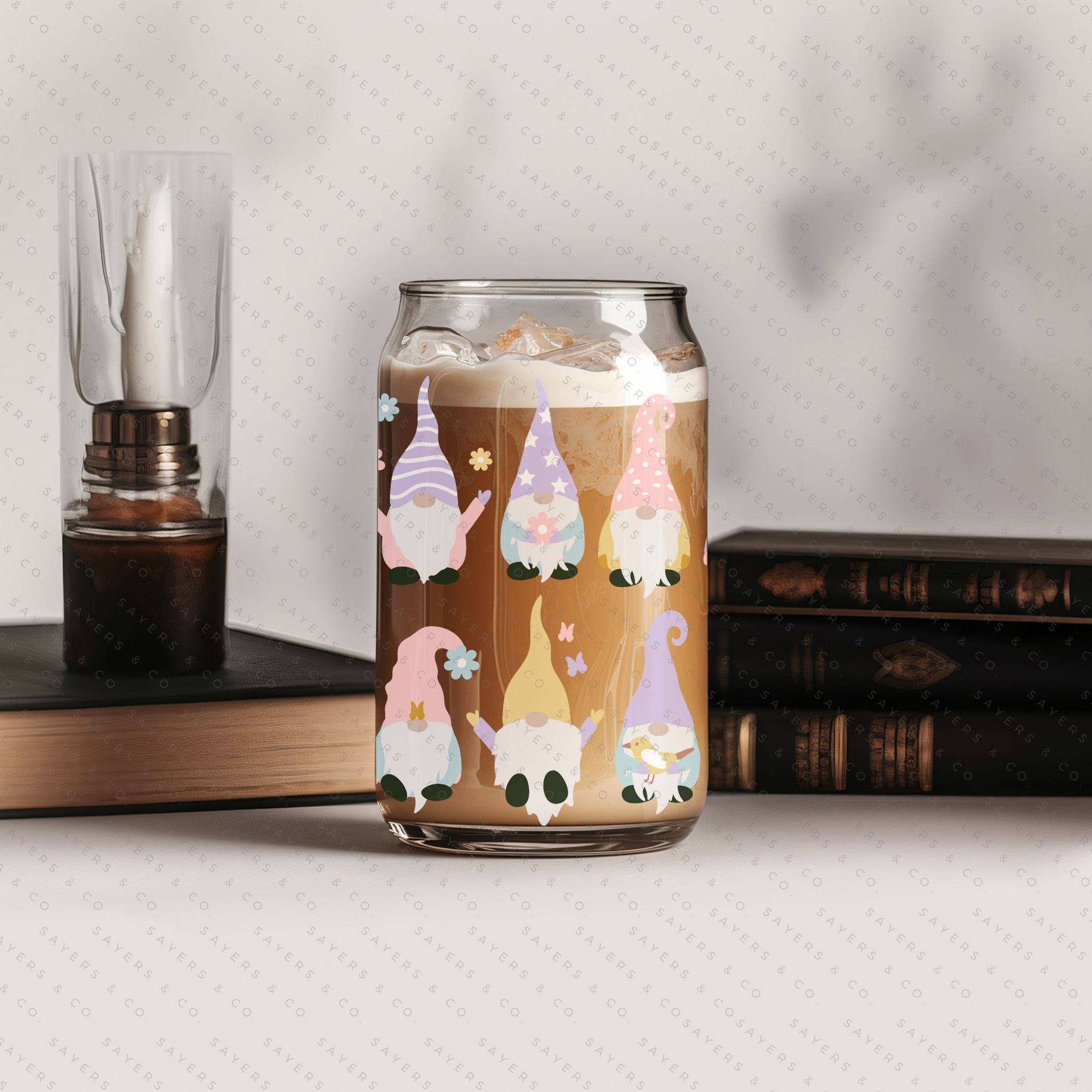 A 16oz clear glass cup featuring a whimsical spring gnome design, complete with a bamboo lid and a clear plastic straw, perfect for various beverages.