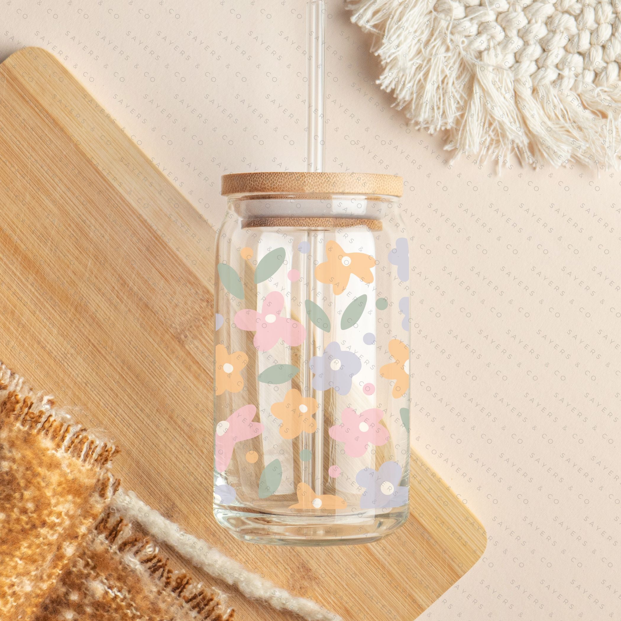16oz Spring Pastel Petals Glass Cup featuring a bamboo lid and straw, adorned with colorful floral designs, perfect for beverages.