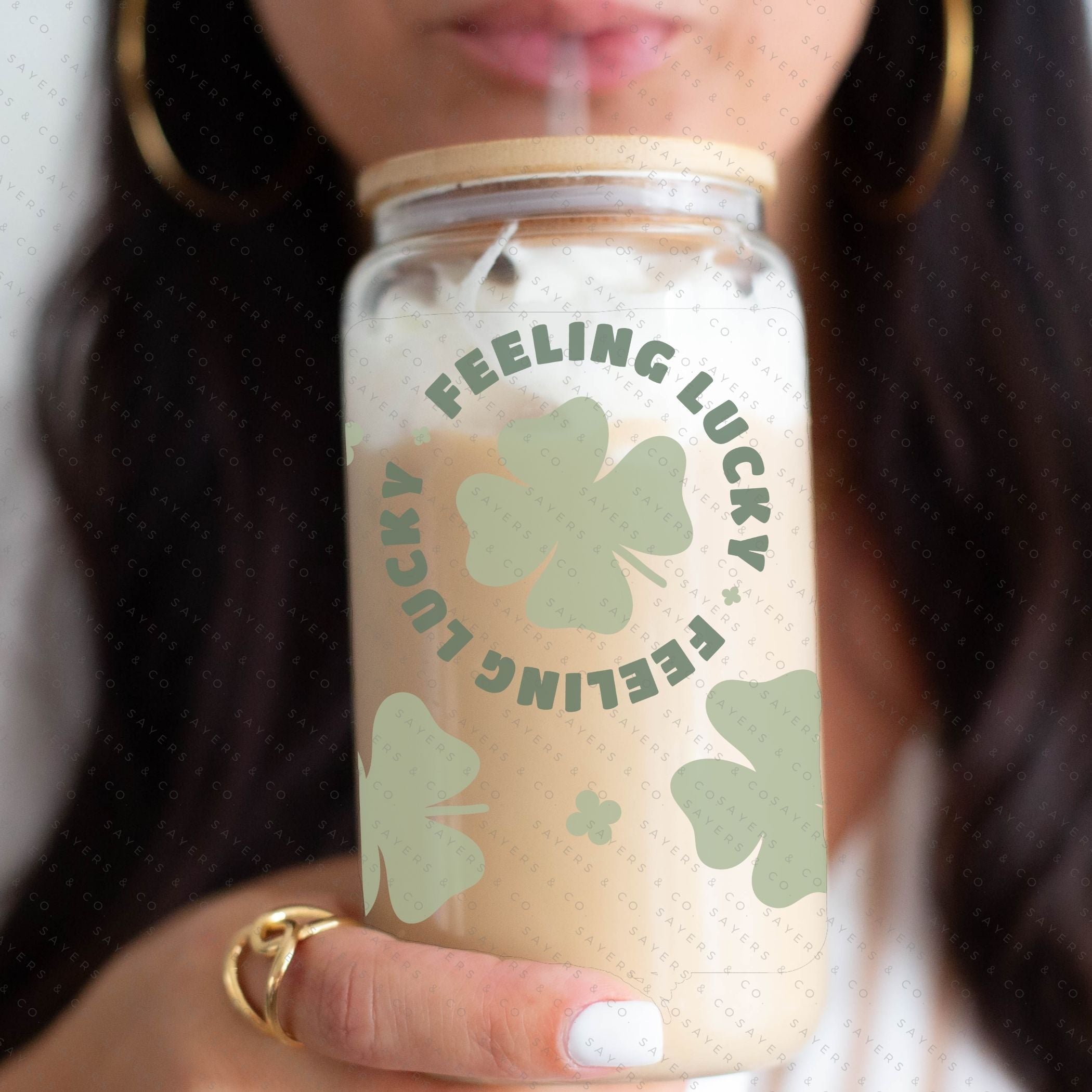 16oz St. Patrick's Day Feeling Lucky Shamrock Glass Cup featuring a bamboo lid and straw, perfect for festive drinks.