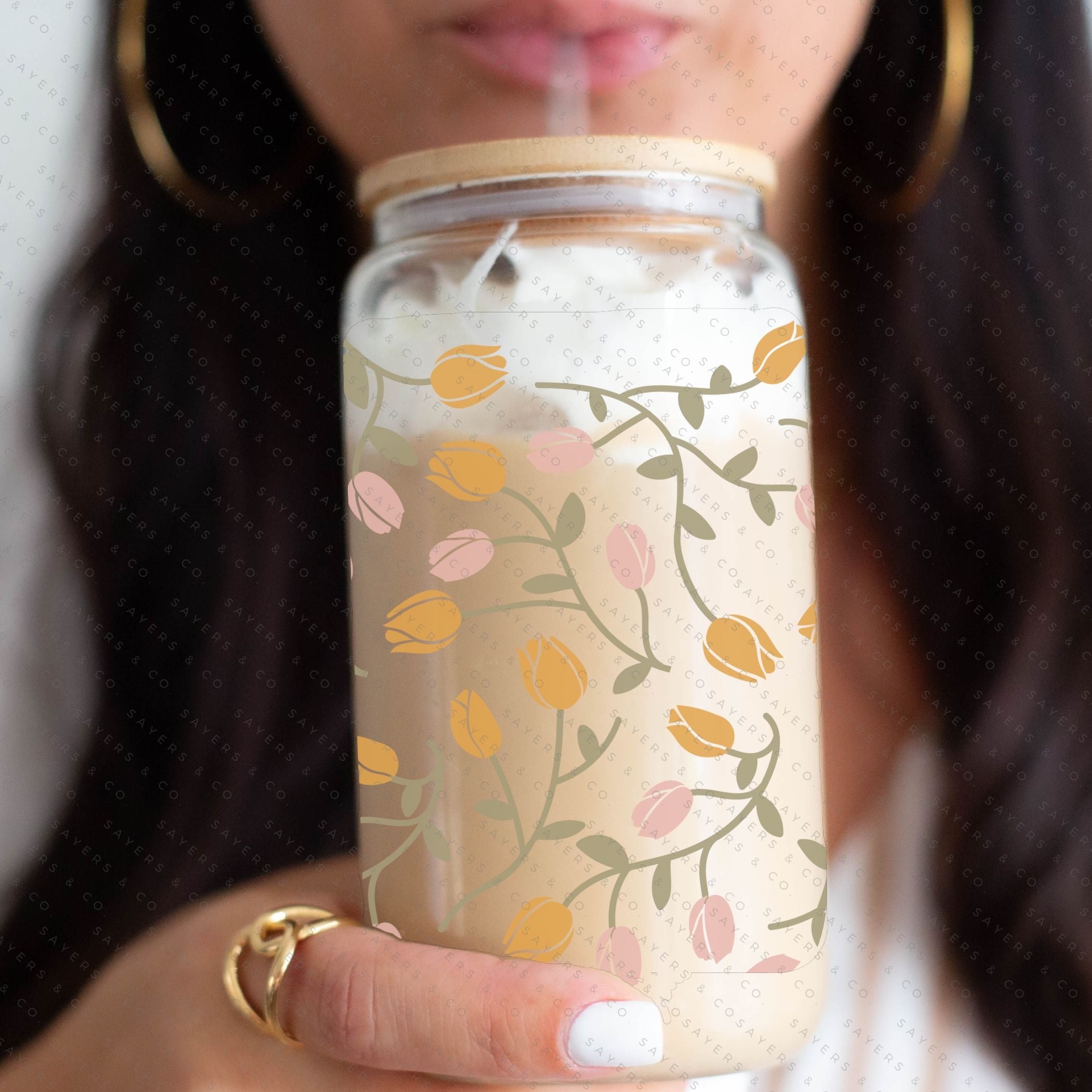 16oz Tulip Entanglement Glass Cup with bamboo lid and straw, featuring a floral design, perfect for beverages.