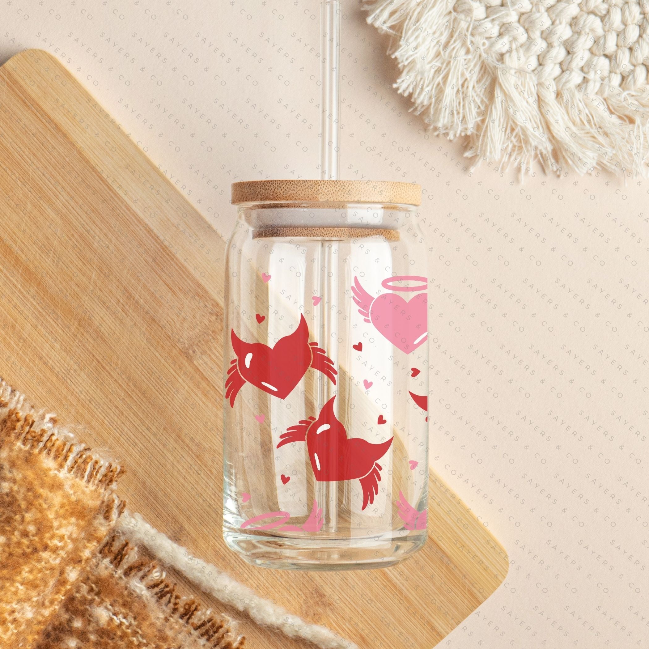 16oz Valentine's Day glass cup featuring angel and devil hearts design, with bamboo lid and clear straw, perfect for beverages.