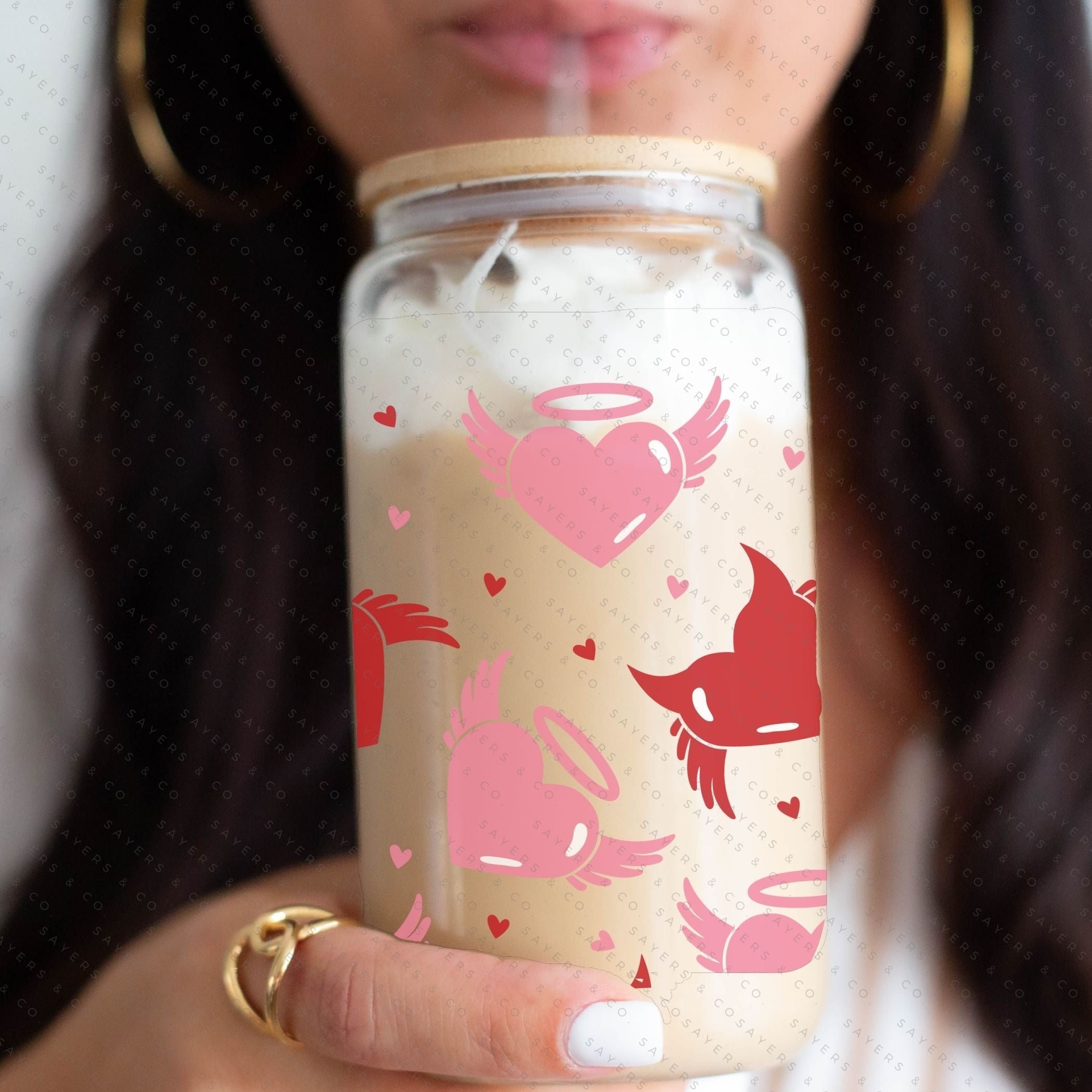 16oz Valentine's Day glass cup featuring angel and devil hearts design, with bamboo lid and clear straw, perfect for beverages.