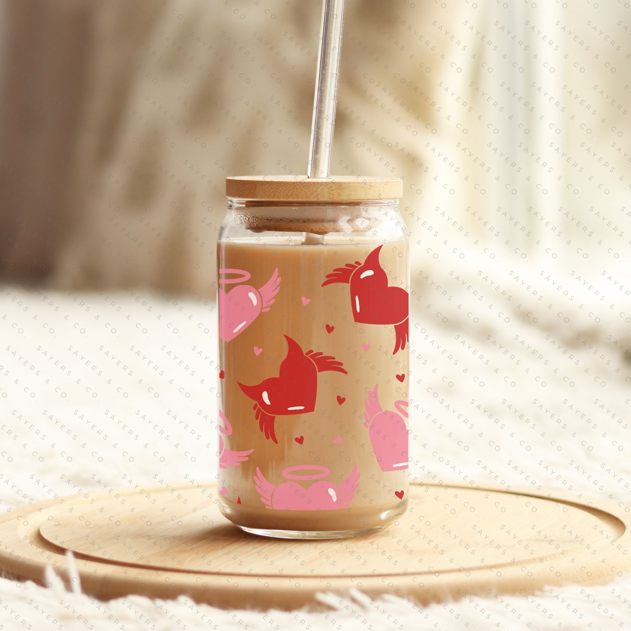 16oz Valentine's Day glass cup featuring angel and devil hearts design, with bamboo lid and clear straw, perfect for beverages.