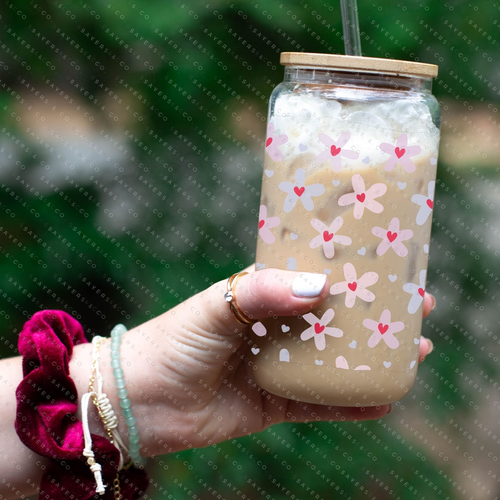 16oz Valentine's Day Daisy Hearts Glass Cup featuring a bamboo lid and straw, showcasing a floral design perfect for gifting.