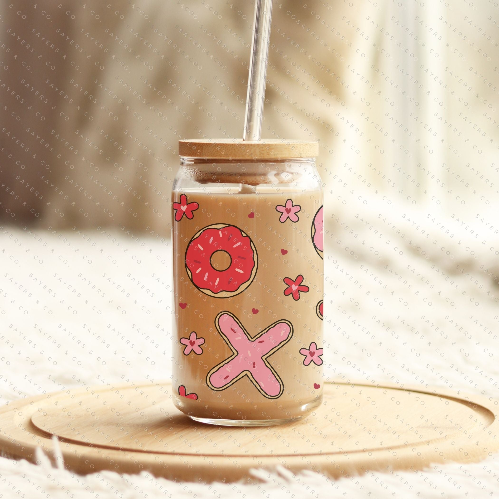 16oz Valentine's Day Xs and Os Donut Glass Cup featuring a bamboo lid and straw, perfect for drinks.