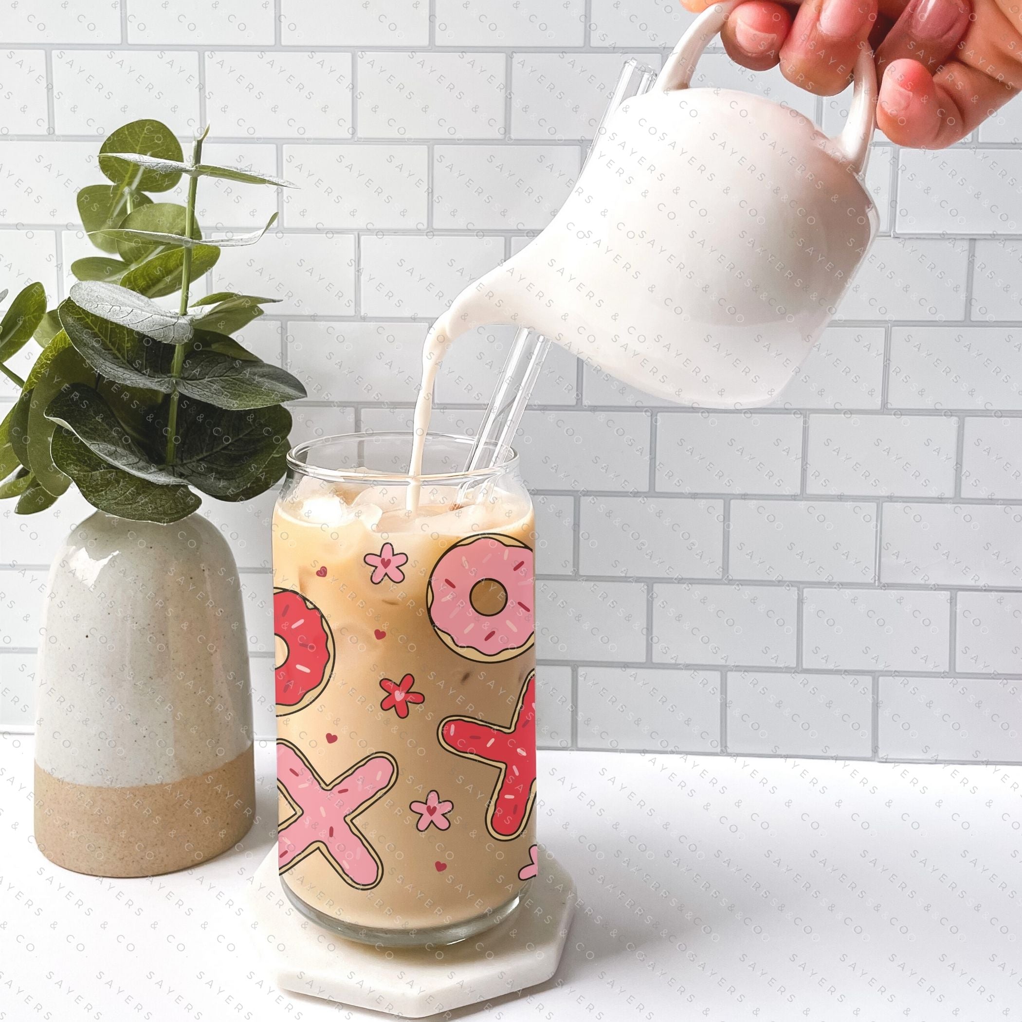 16oz Valentine's Day Xs and Os Donut Glass Cup featuring a bamboo lid and straw, perfect for drinks.