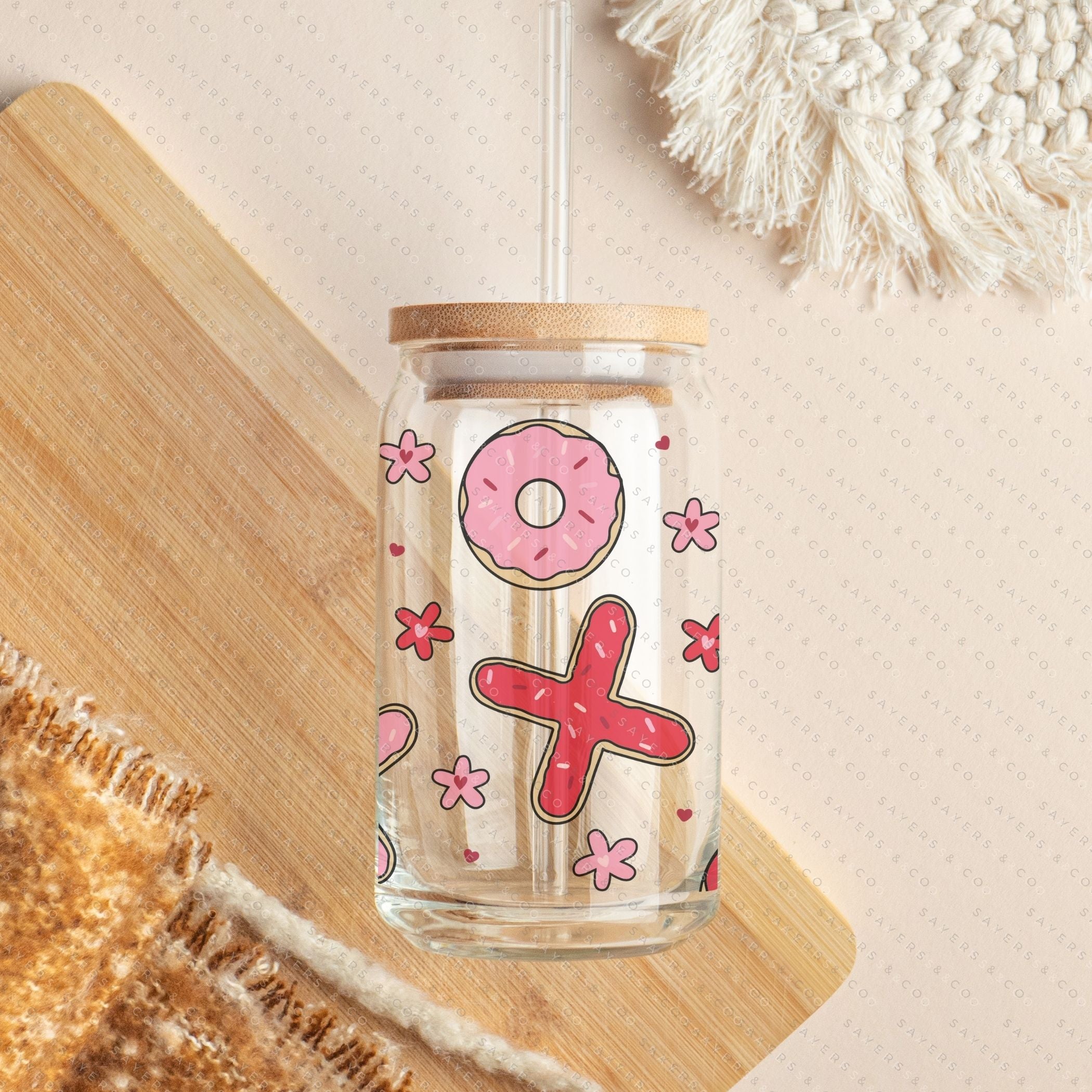 16oz Valentine's Day Xs and Os Donut Glass Cup featuring a bamboo lid and straw, perfect for drinks.