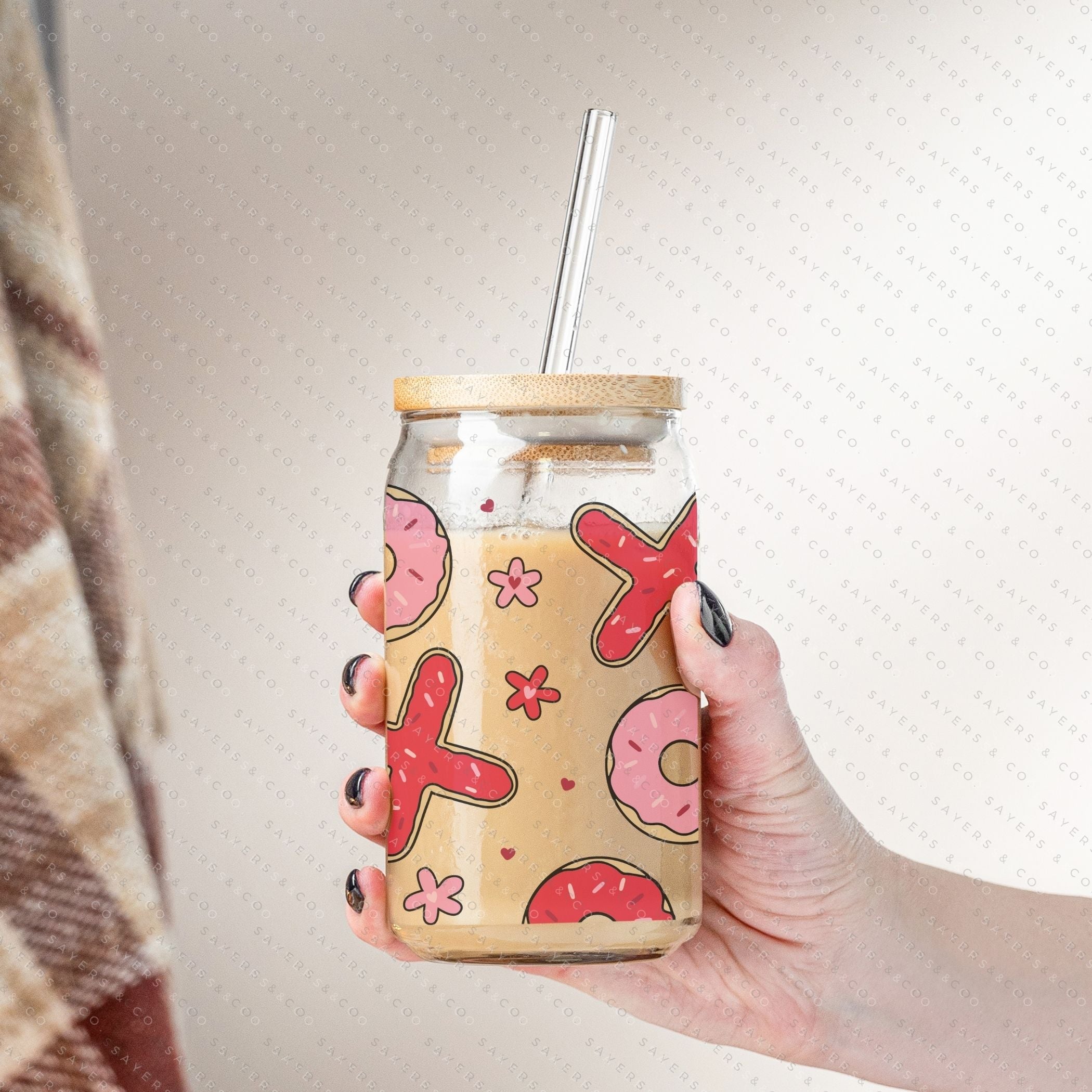 16oz Valentine's Day Xs and Os Donut Glass Cup featuring a bamboo lid and straw, perfect for drinks.