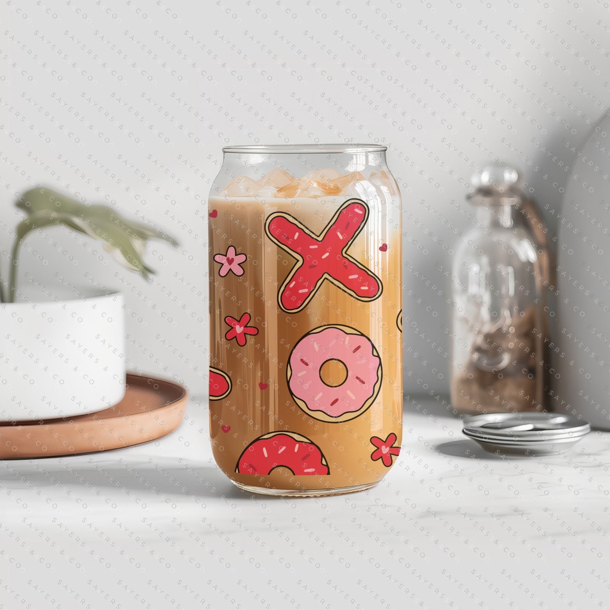 16oz Valentine's Day Xs and Os Donut Glass Cup featuring a bamboo lid and straw, perfect for drinks.