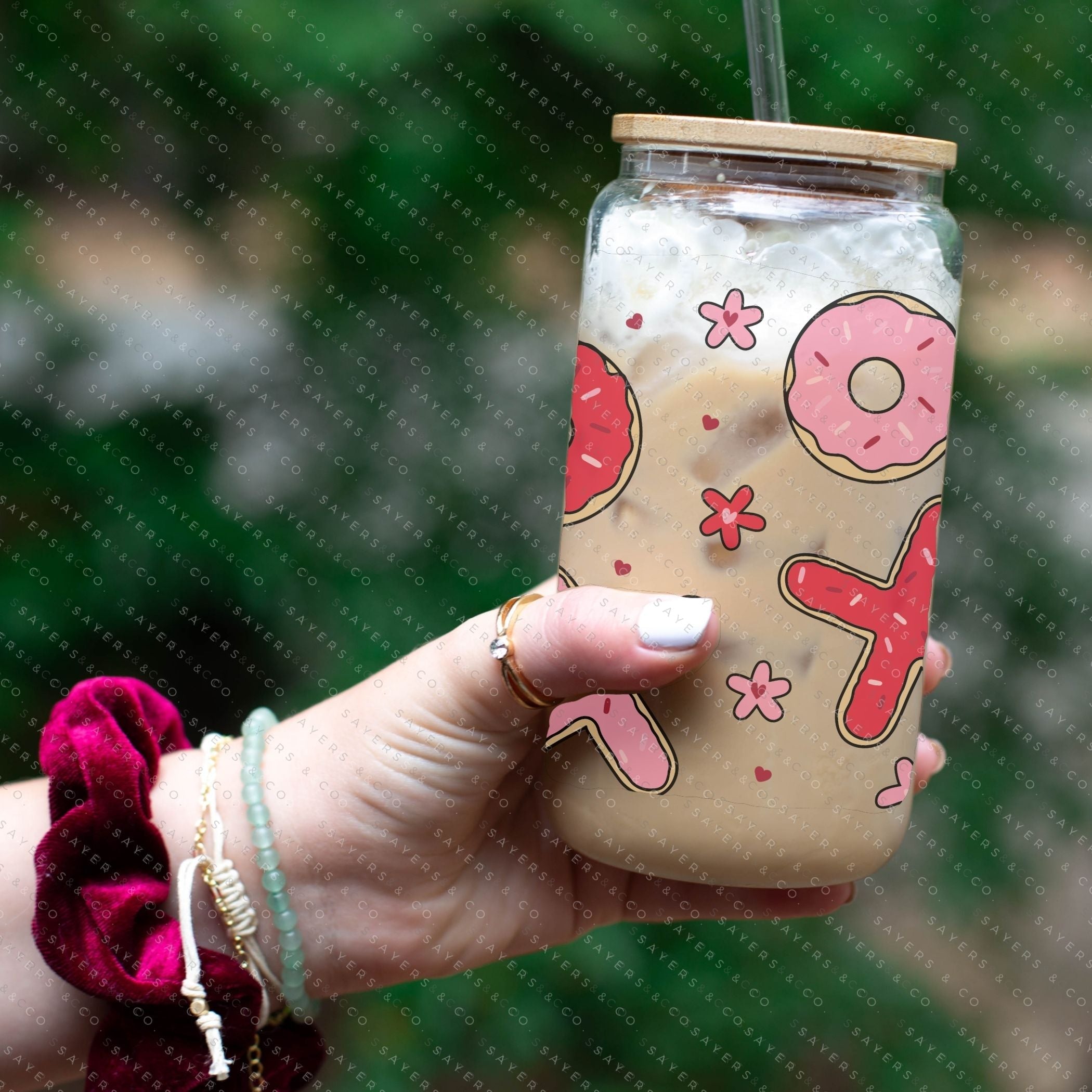 16oz Valentine's Day Xs and Os Donut Glass Cup featuring a bamboo lid and straw, perfect for drinks.