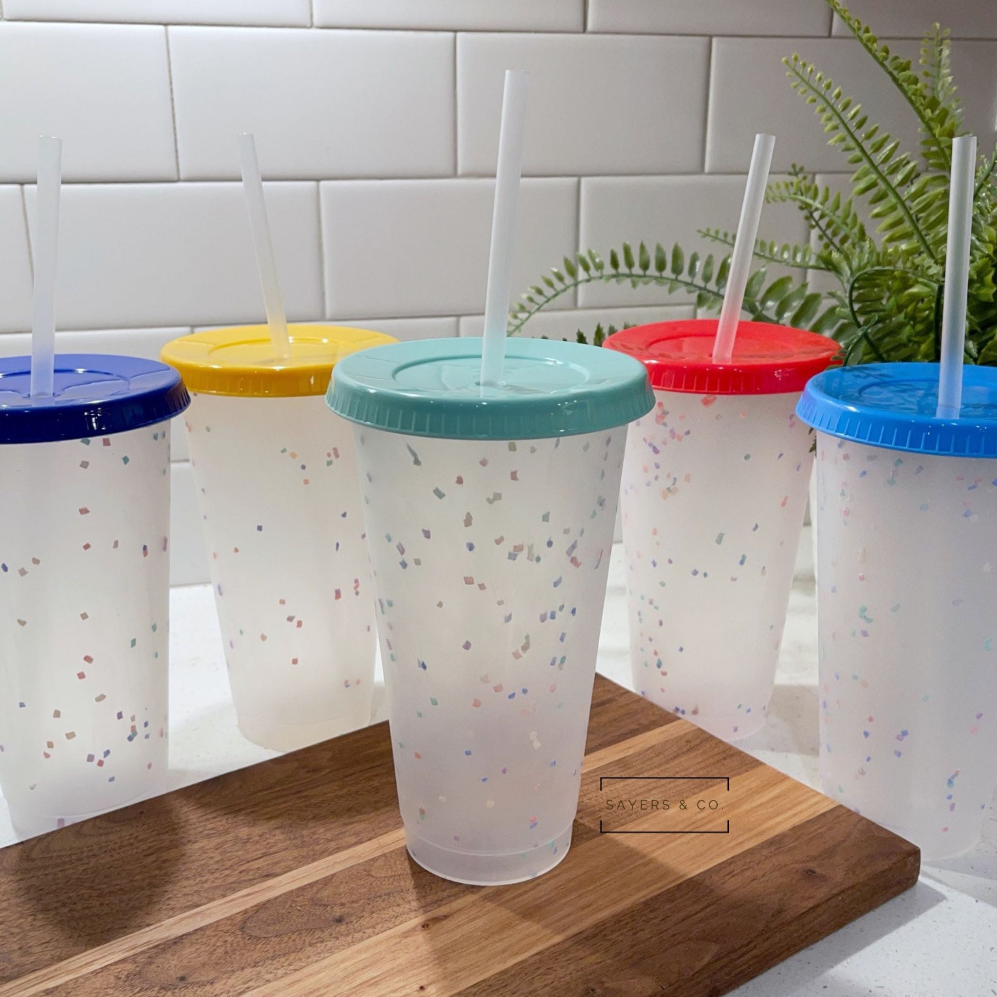 A pack of five 24oz color changing confetti cold cups with straws and lids, showcasing vibrant colors and a fun design.