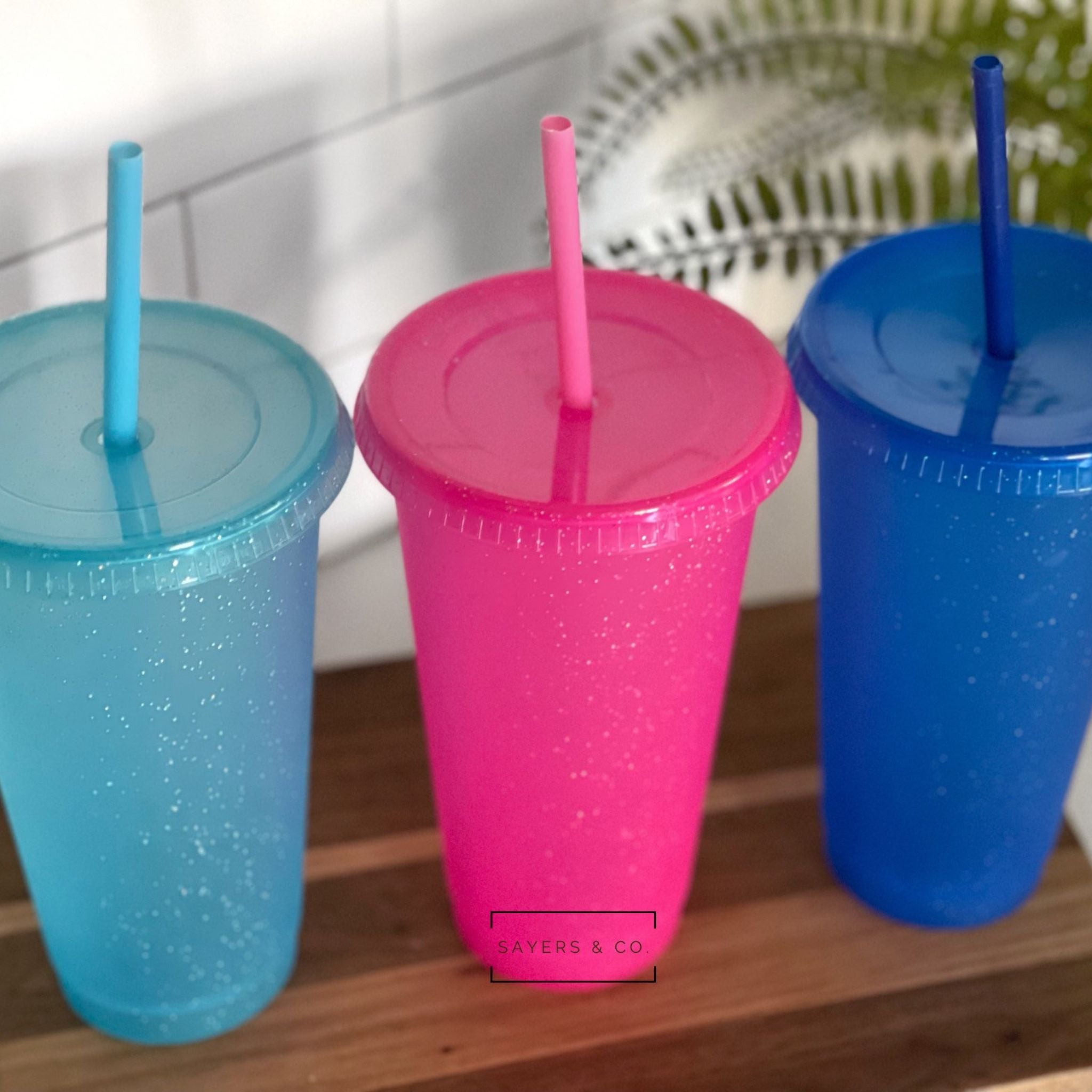 24oz Matte Glitter Cold Cup in aqua, pink, and blue glitter options, alongside a matte black version, with matching straw and lid.