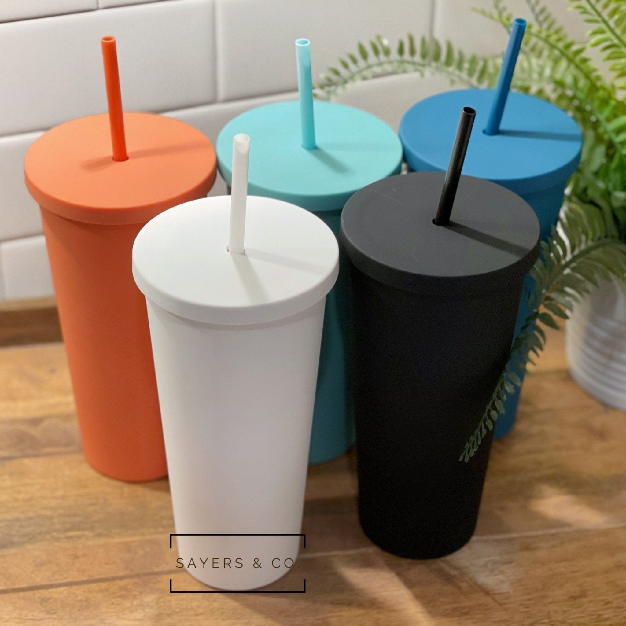 A 22oz Acrylic Matte Colored Double Walled Tumbler in various colors with a screwtop lid and matching straw, showcasing its stylish design.