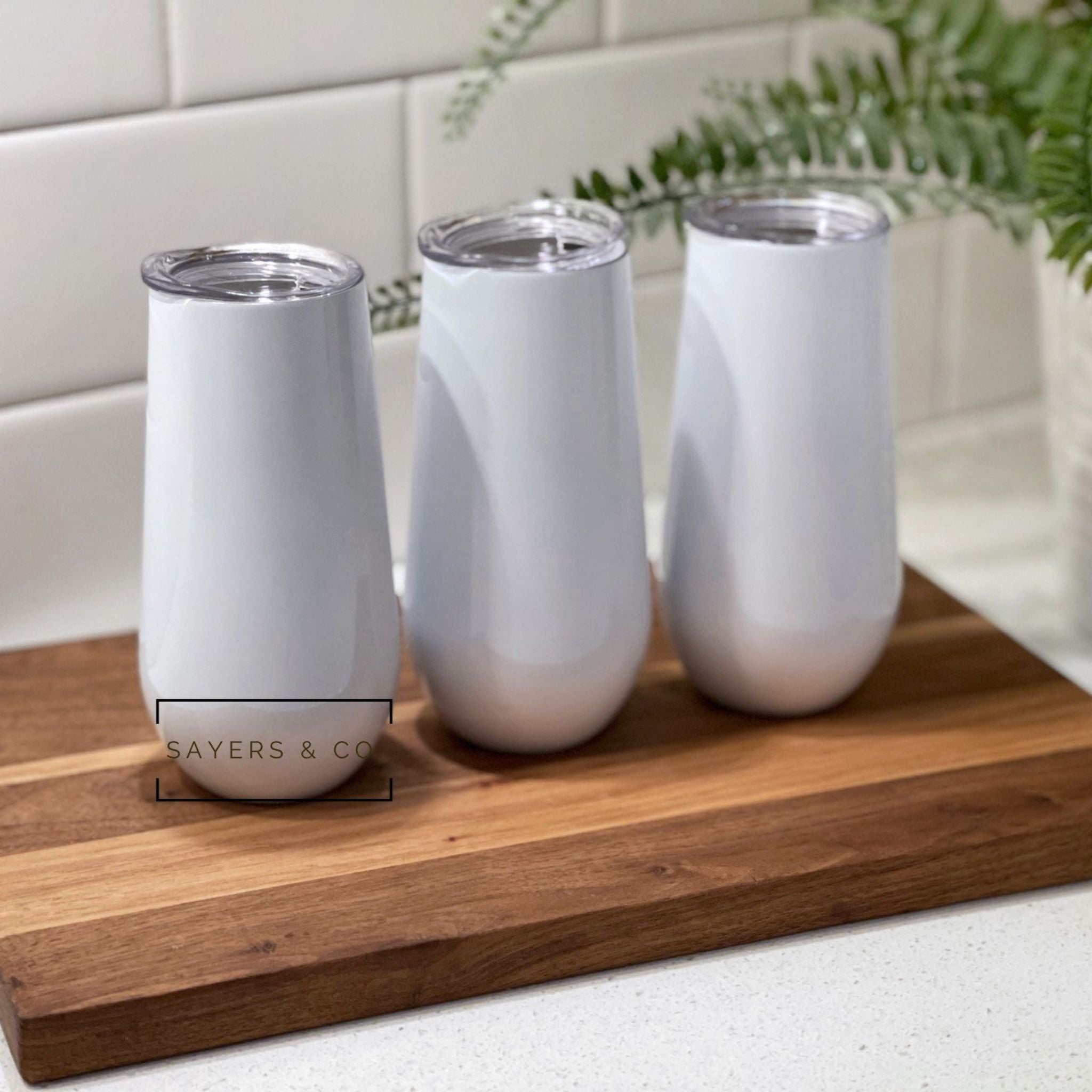 Three sizes of white stemless champagne tumblers for sublimation printing, showcasing elegant design and stainless steel material.