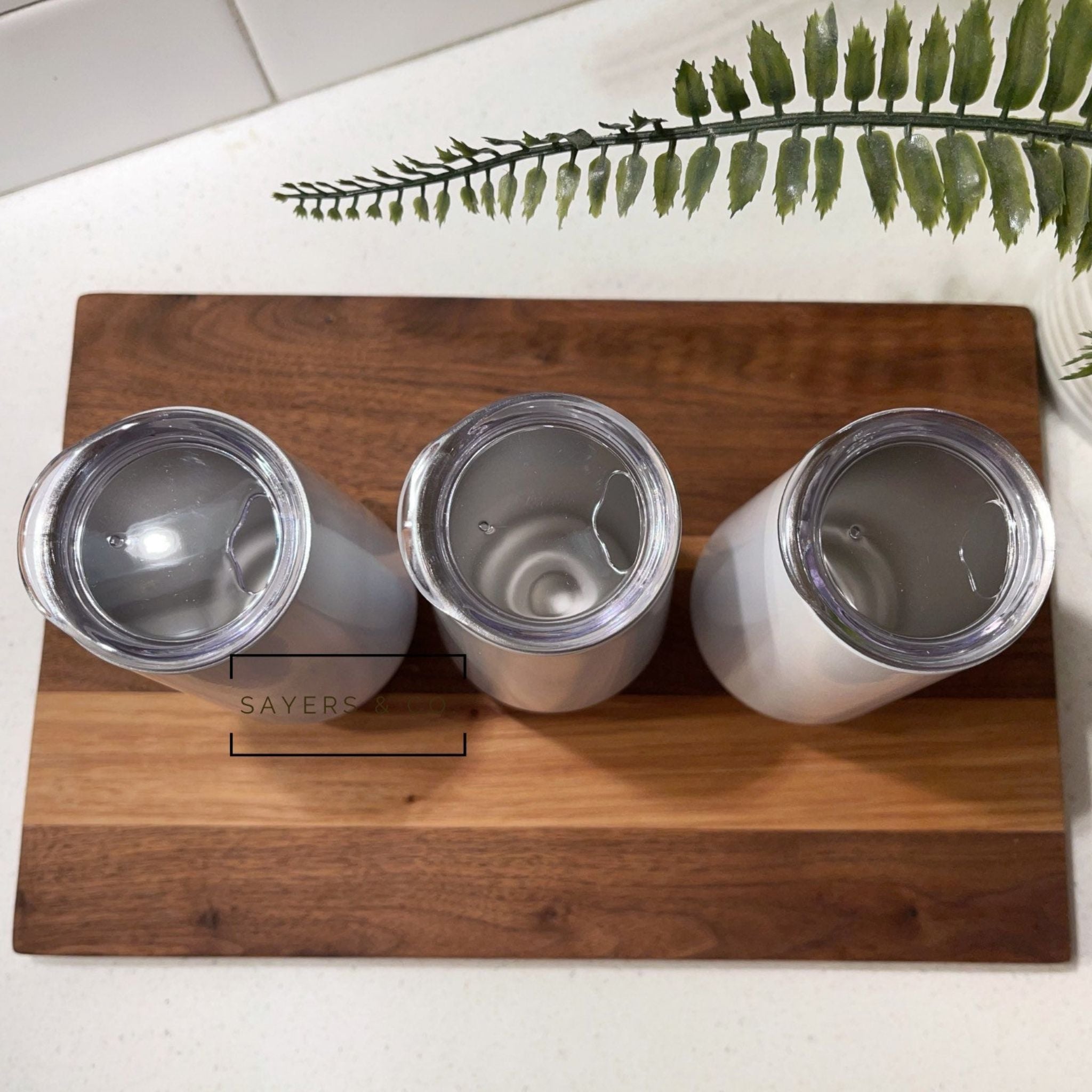 Three sizes of white stemless champagne tumblers for sublimation printing, showcasing elegant design and stainless steel material.