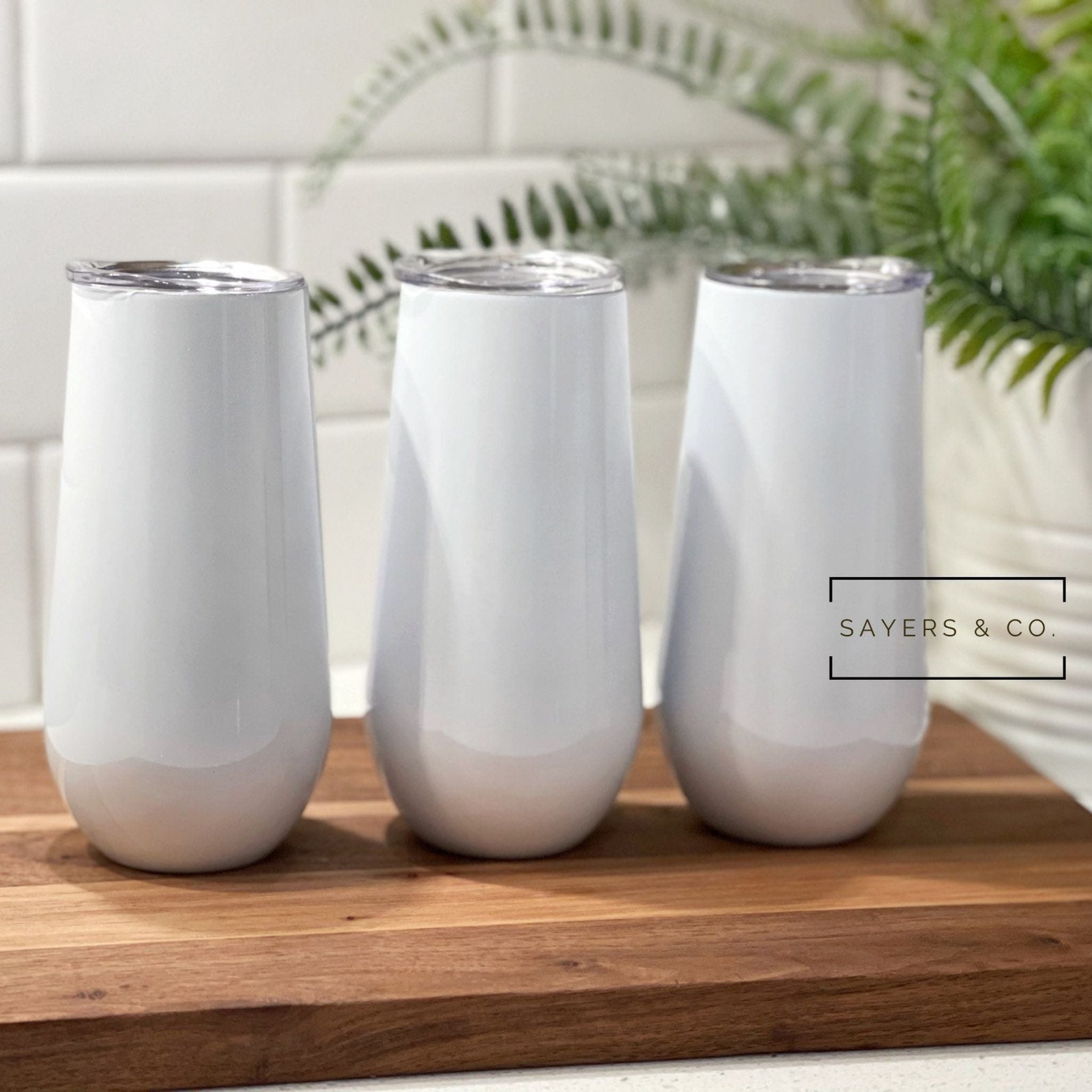 Three sizes of white stemless champagne tumblers for sublimation printing, showcasing elegant design and stainless steel material.