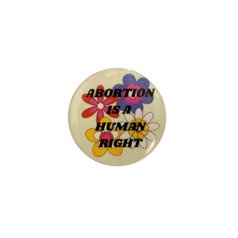 1.25-inch button with the text 'Abortion is a Human Right' surrounded by a colorful groovy flower design.