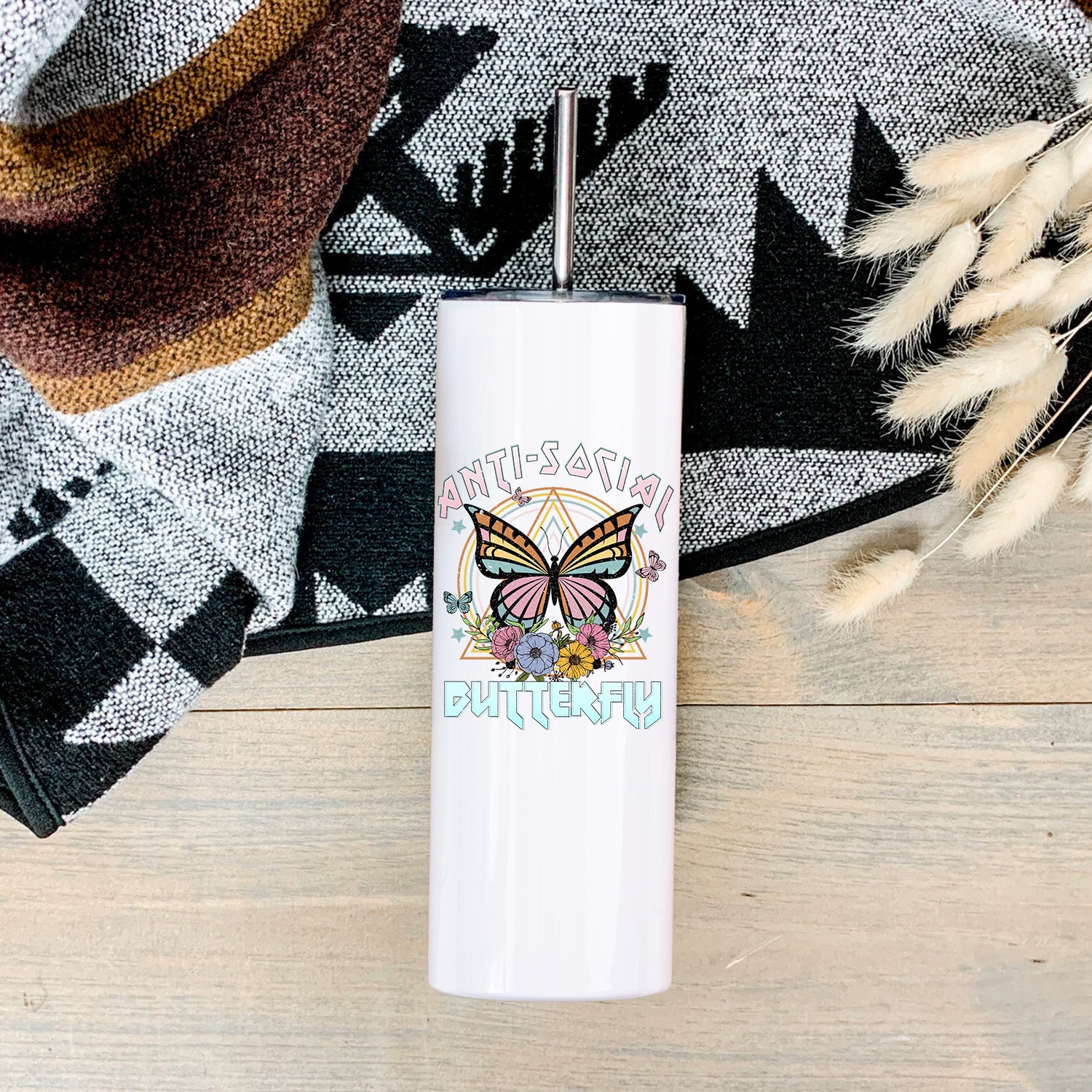Anti-Social Butterfly Skinny Tumbler in vibrant colors with a clear lid and stainless steel straw, showcasing its sleek design.