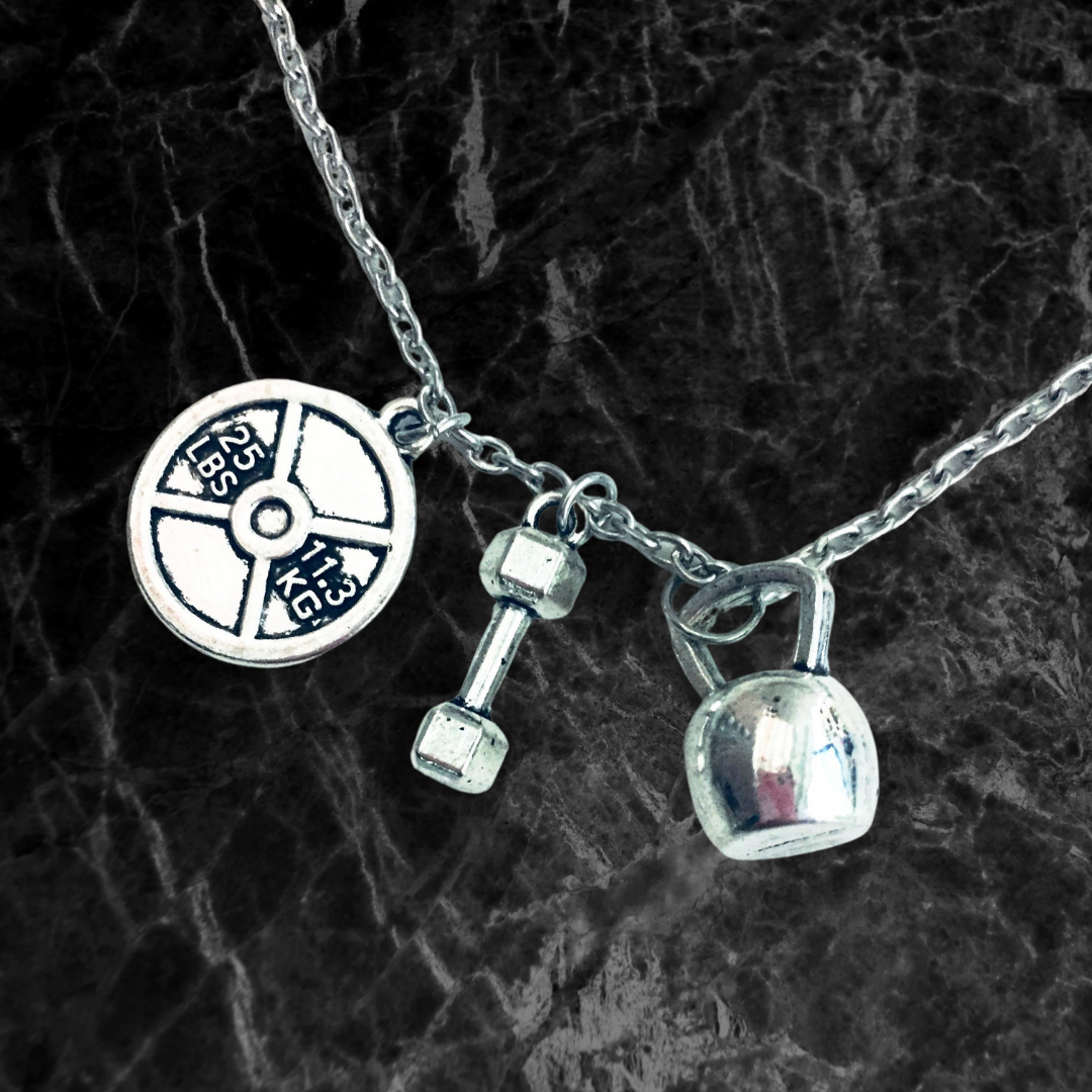 Badass Weightlifter Triple Charm Necklace in Silvertone featuring kettlebell, dumbbell, and weight plate charms.