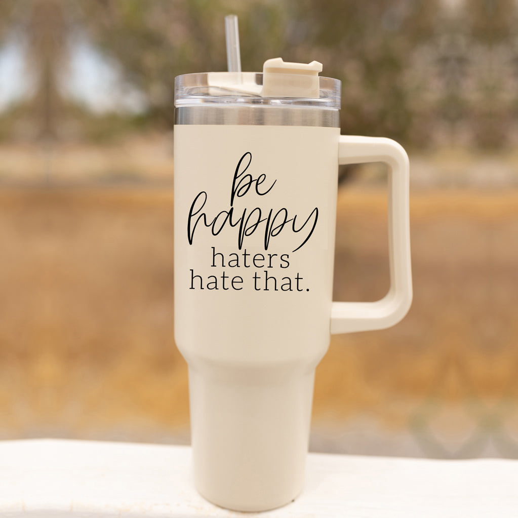 Be Happy 40oz insulated mug with handle, lid, and straw, featuring a matte cream finish and black graphic design.