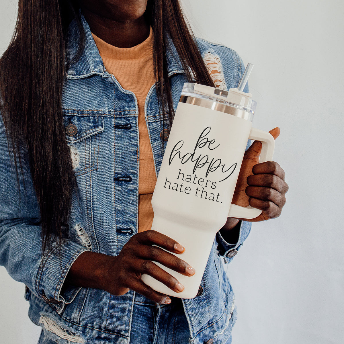 Be Happy 40oz insulated mug with handle, lid, and straw, featuring a matte cream finish and black graphic design.