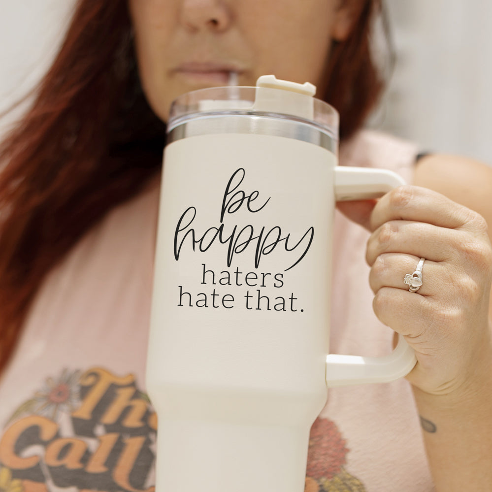 Be Happy 40oz insulated mug with handle, lid, and straw, featuring a matte cream finish and black graphic design.