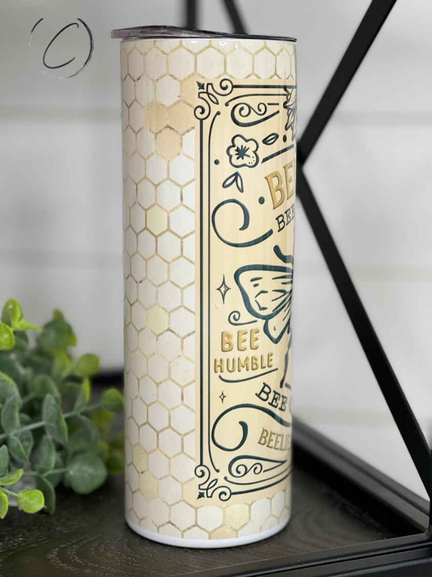 Bee Kind 20oz Skinny Tumbler with a vibrant full wrap design, featuring a reusable straw and durable construction.