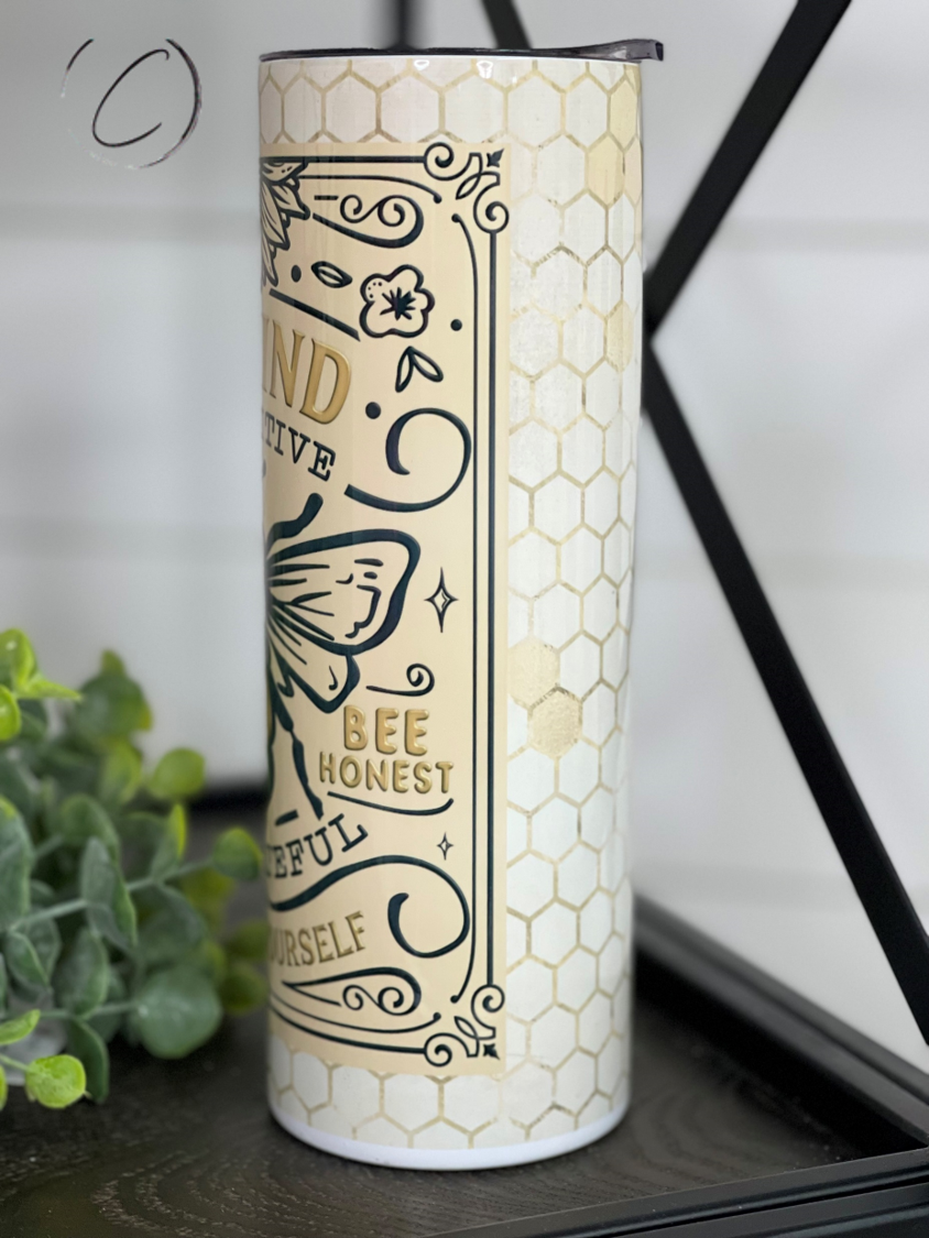 Bee Kind 20oz Skinny Tumbler with a vibrant full wrap design, featuring a reusable straw and durable construction.