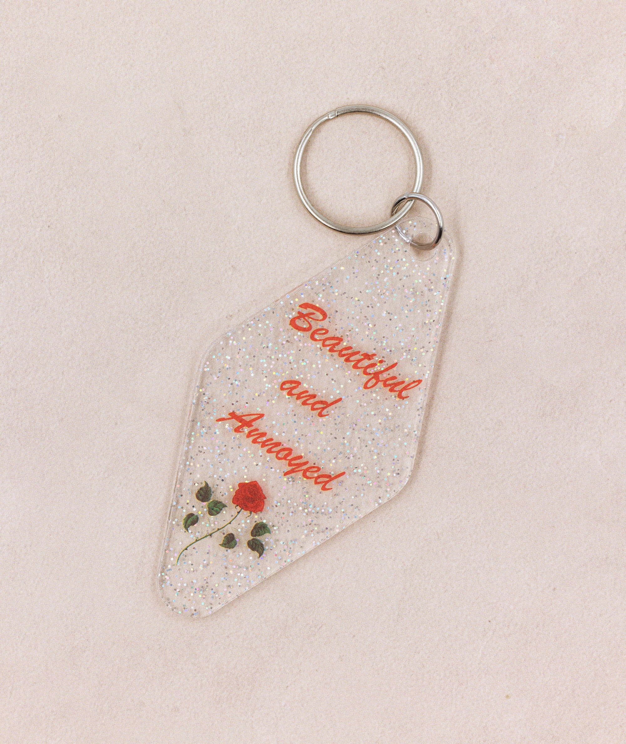 Beautiful and Annoyed Motel Style Key Tag Keychain with clear glitter design, featuring the phrase 'Beautiful and Annoyed' in bold letters.