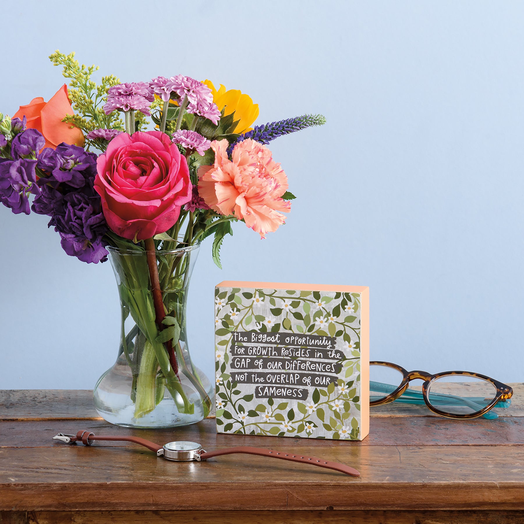 A colorful wooden block sign with an inspirational quote about growth and diversity, measuring 4 inches by 4 inches.
