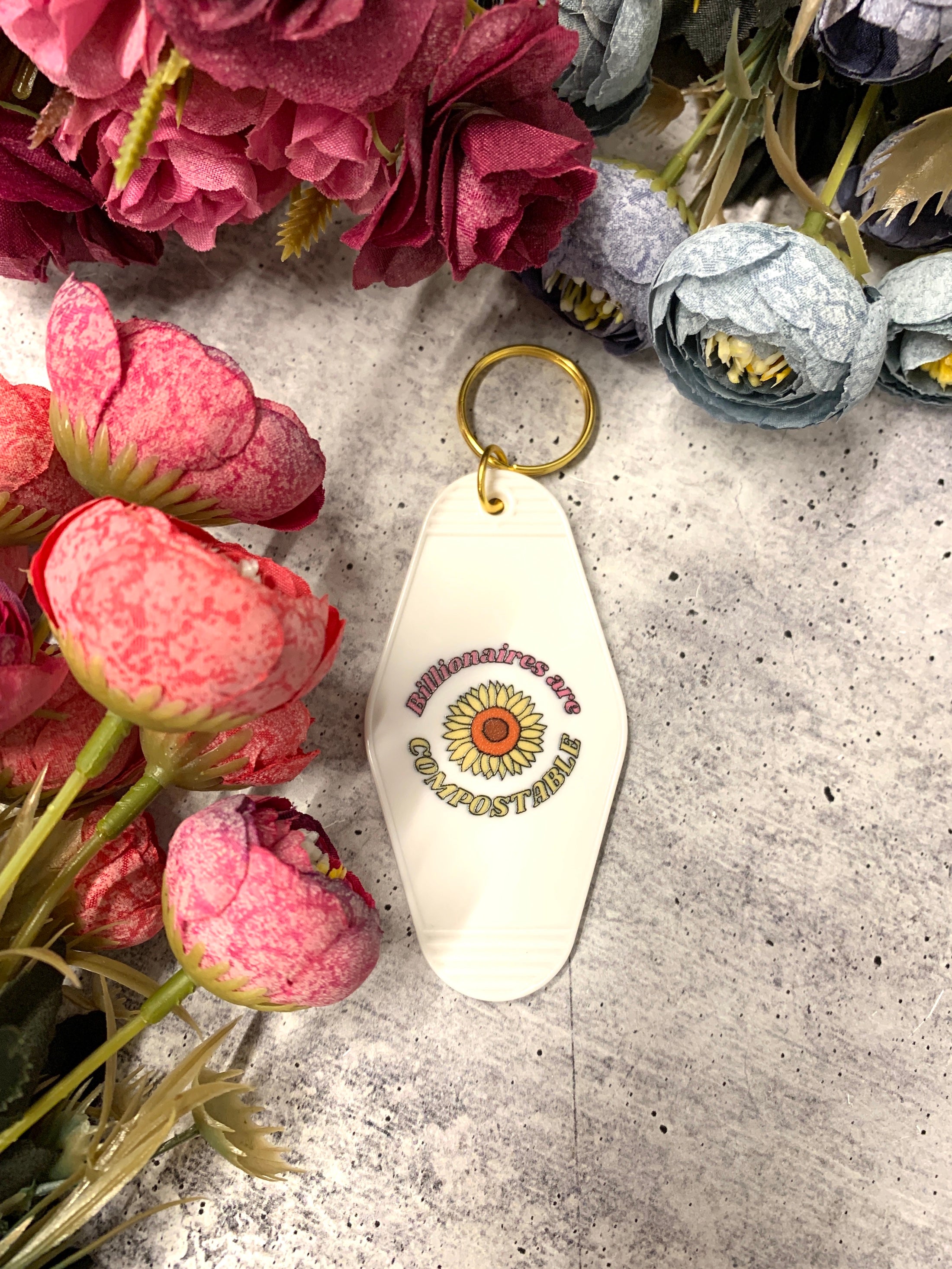 Billionaires Are Compostable motel-style keychain featuring bold text and a classic design, perfect for expressing anti-plutocracy sentiments.