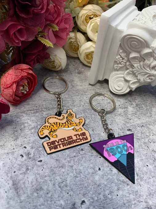 Born in the 1900s enamel keychain featuring vibrant colors and retro design, attached to a split ring.