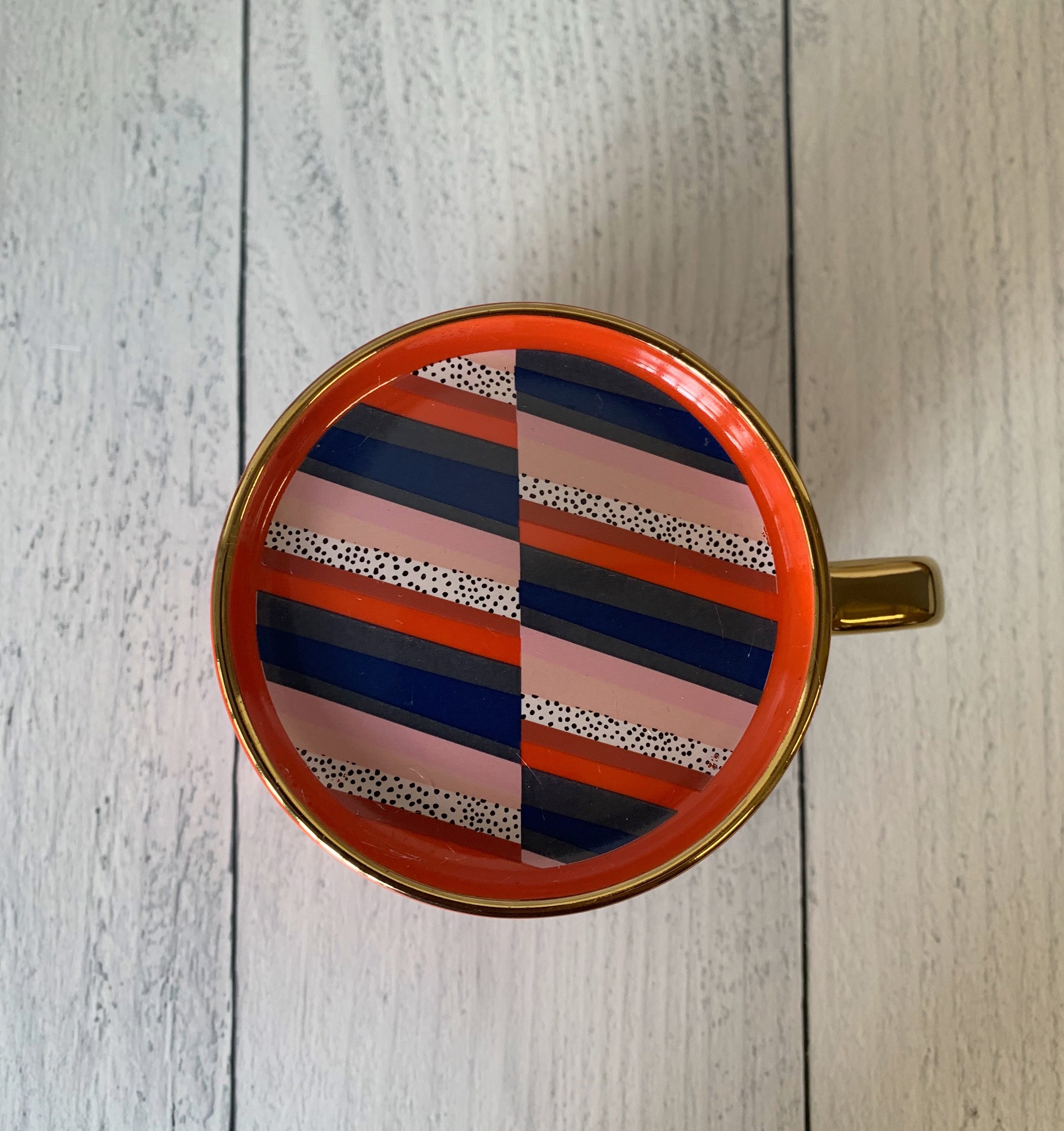 A stylish red and gold ceramic mug with 'BOSSY' printed on it, accompanied by a matching coaster lid.