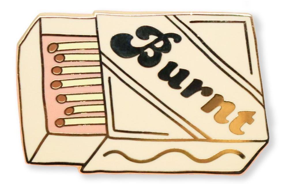 Burnt enamel pin featuring gold detailing, showcasing a stylish design with a cloisonne finish.