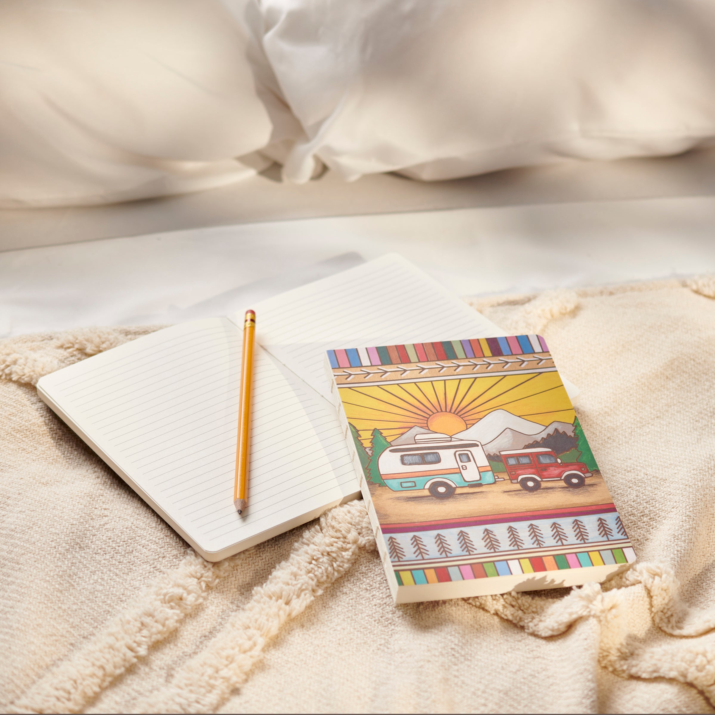 Camper Double-Sided Journal featuring wood burned art of a vehicle pulling a camper in the woods, with lined pages and open spine design.