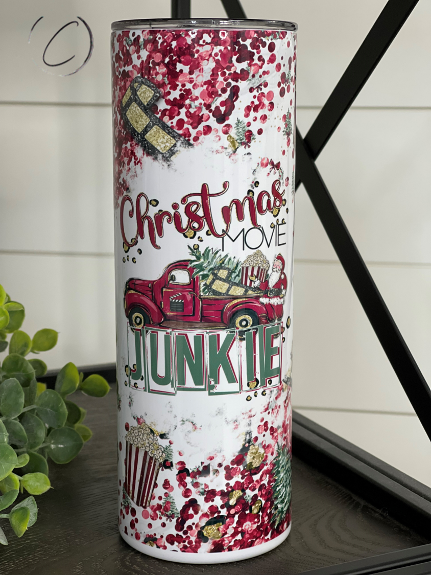 A festive 20oz skinny tumbler featuring a Christmas movie design, complete with a reusable straw, perfect for holiday drinks.