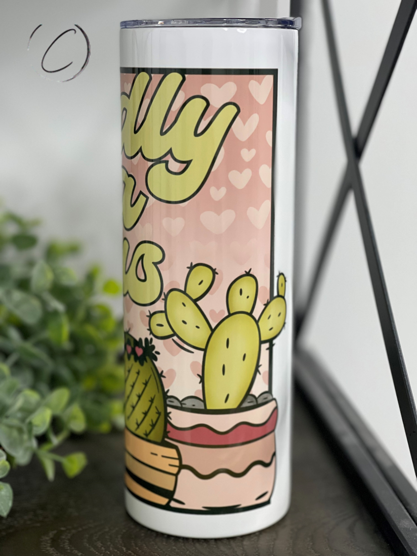 Cuddly As A Cactus 20oz Skinny Tumbler featuring a vibrant cactus design, reusable straw, and insulated body.
