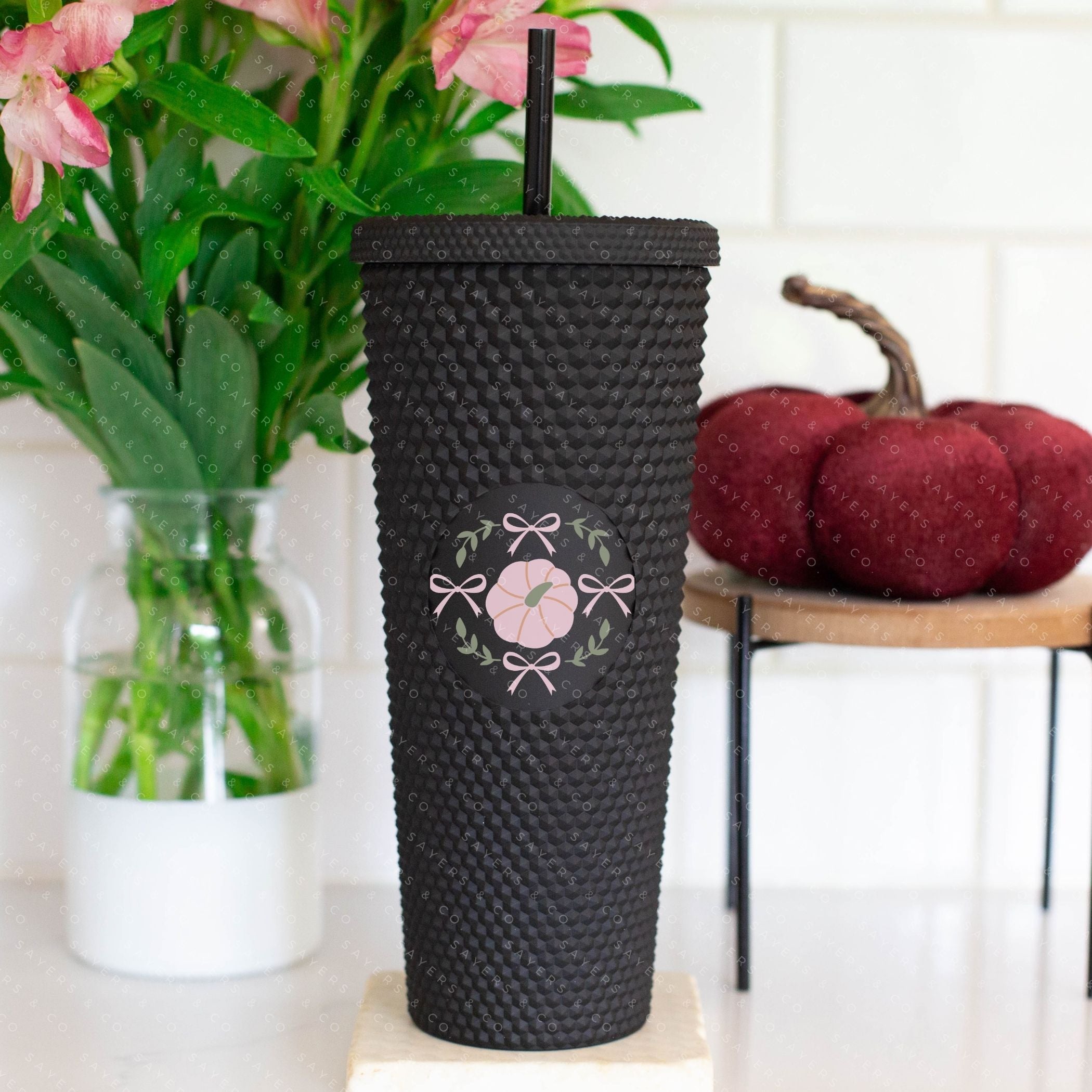 Custom Studded 24oz Double Walled Tumbler in pink pumpkin design, featuring a lid and straw, perfect for fall beverages.