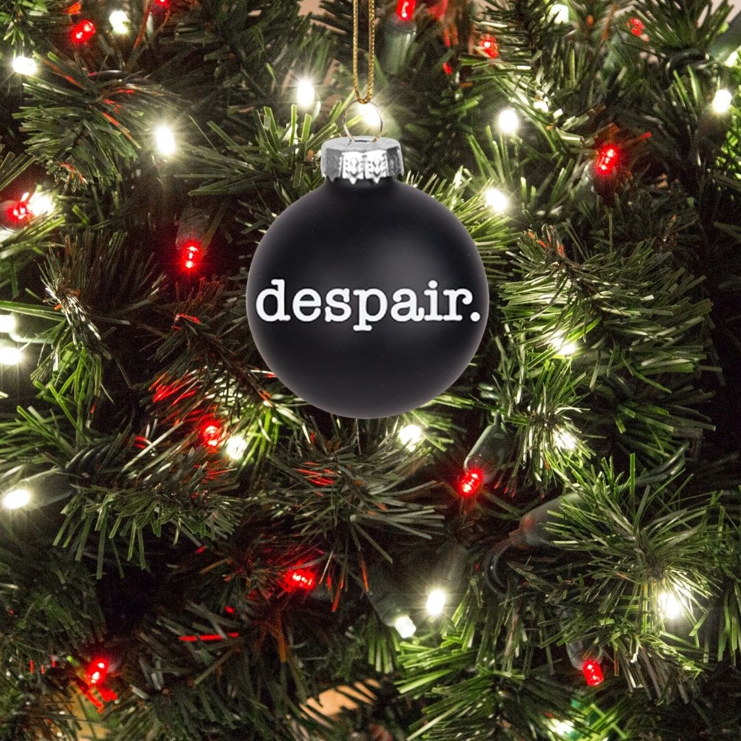 A 2-inch black glass ornament with a despair theme, featuring a string for hanging, symbolizing holiday angst.