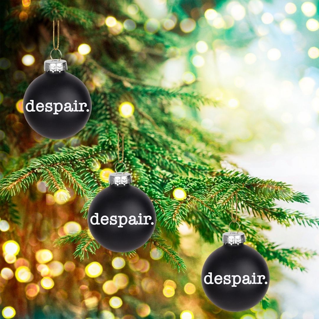 A 2-inch black glass ornament with a despair theme, featuring a string for hanging, symbolizing holiday angst.