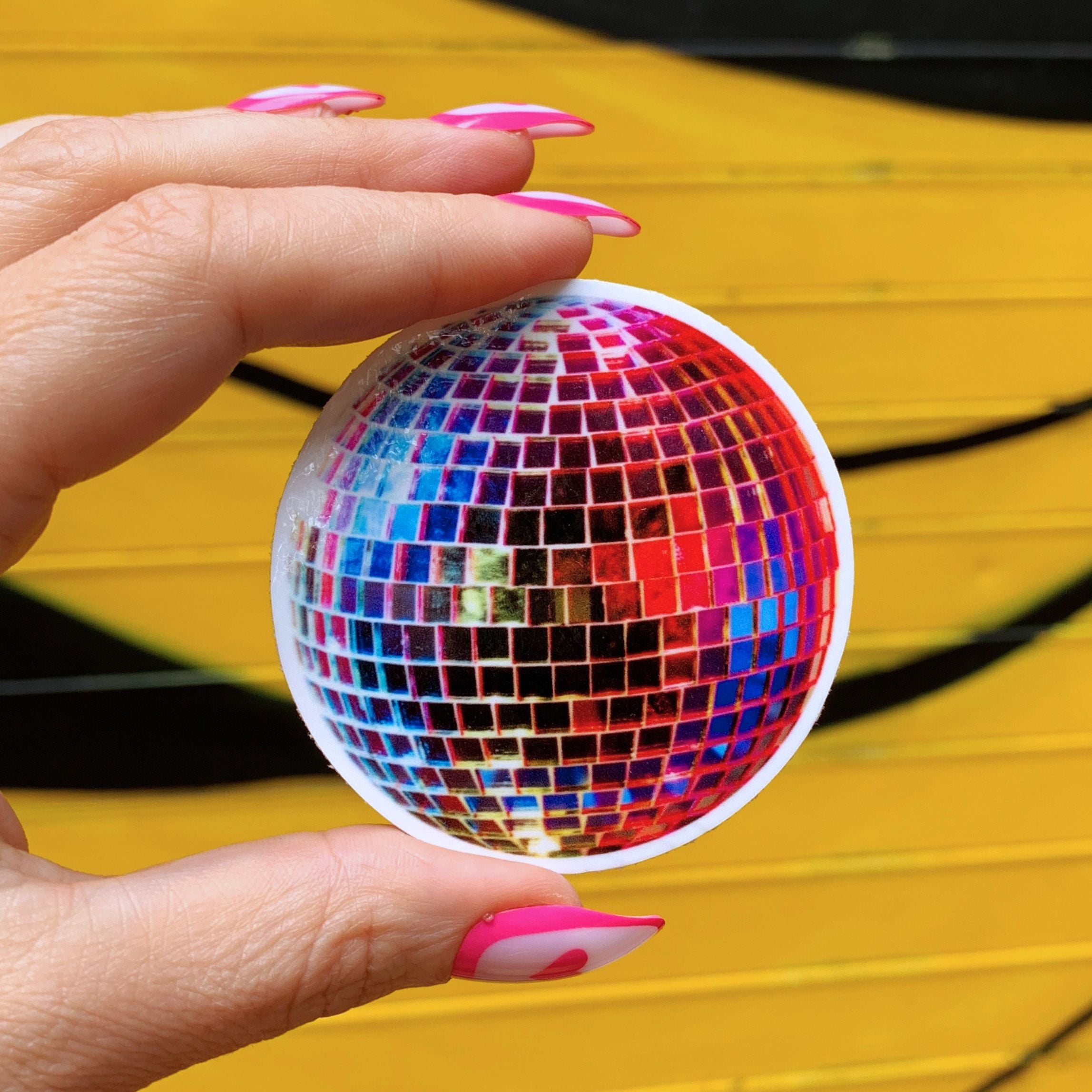 A vibrant 70's retro vinyl disco ball sticker, 2.5 inches in size, showcasing a glossy finish.