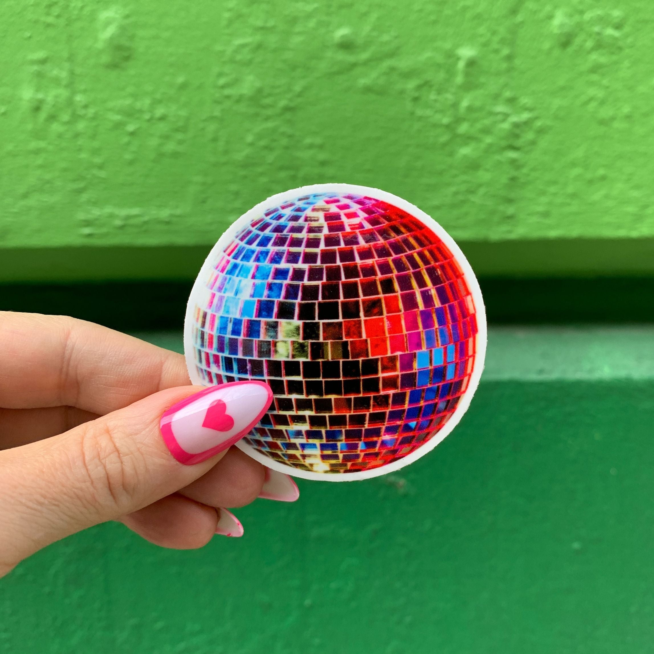 A vibrant 70's retro vinyl disco ball sticker, 2.5 inches in size, showcasing a glossy finish.