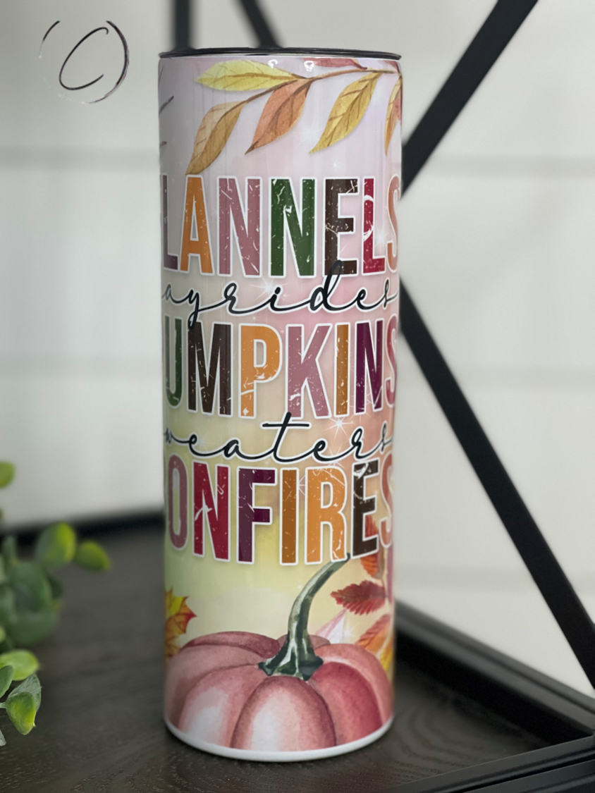 A stylish 20oz skinny tumbler featuring a full wrap design of flannels, pumpkins, and bonfires, perfect for autumn beverages.