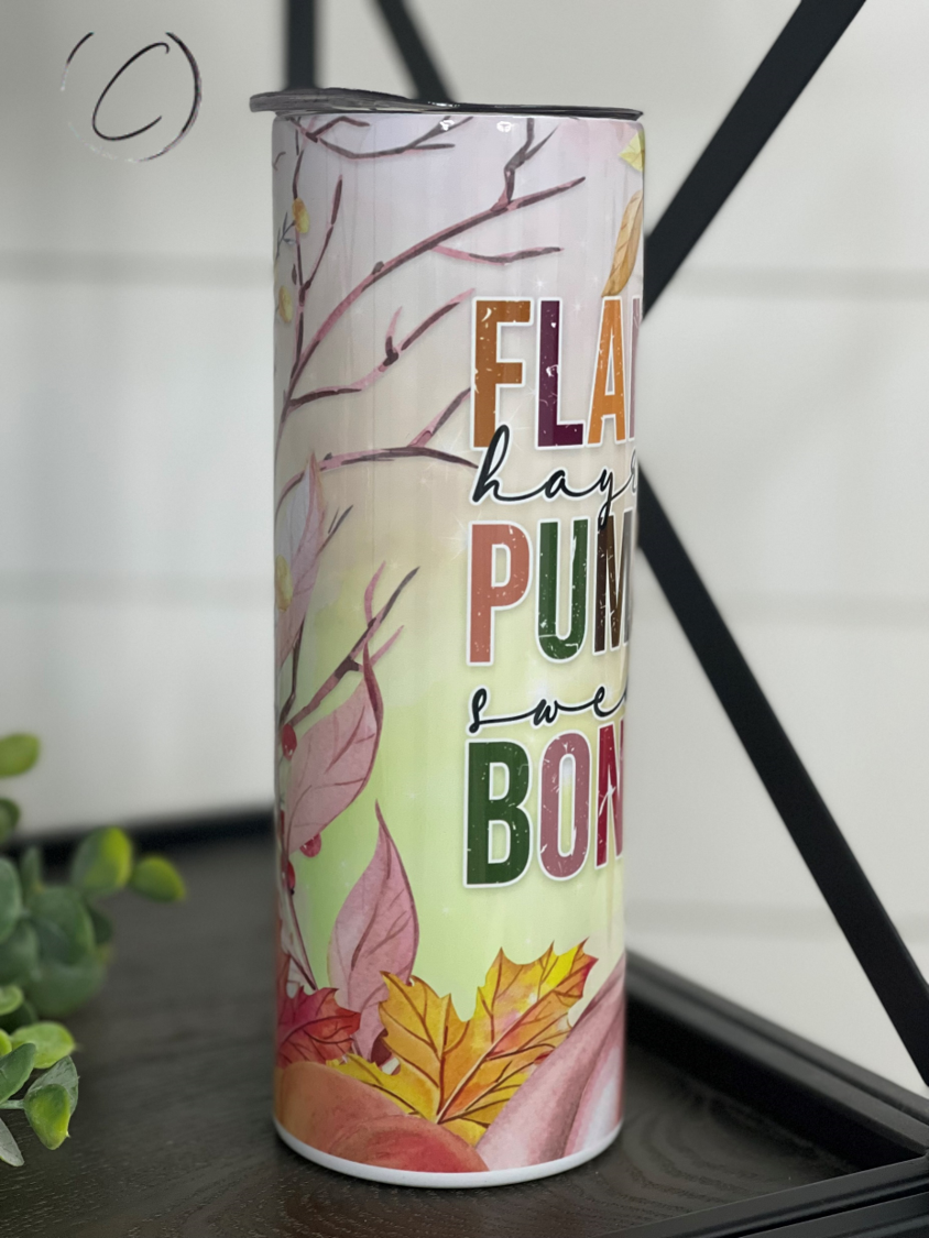 A stylish 20oz skinny tumbler featuring a full wrap design of flannels, pumpkins, and bonfires, perfect for autumn beverages.