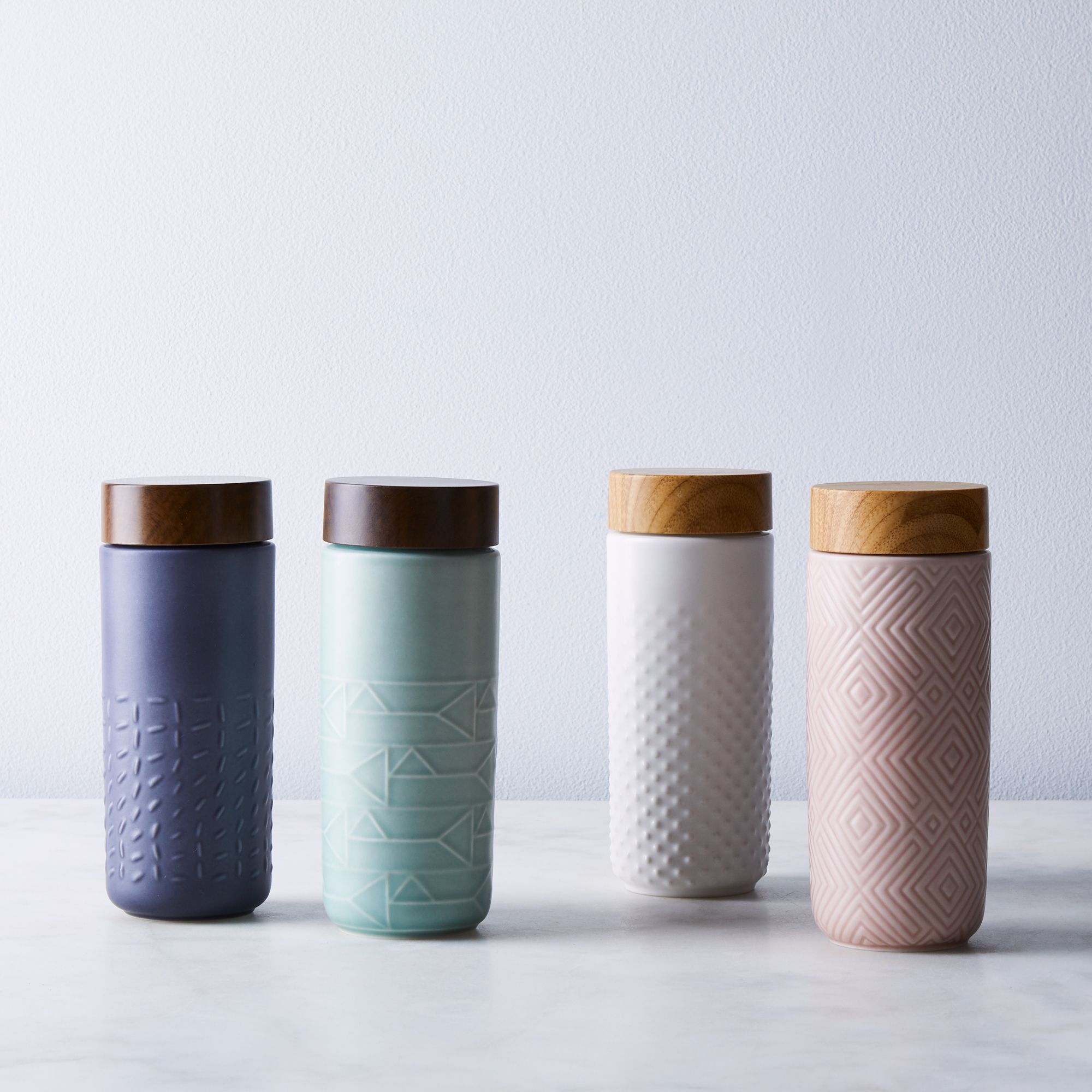 Footprint Ceramic Travel Mug with embossed design and tourmaline lining, showcasing its elegant shape and eco-friendly materials.